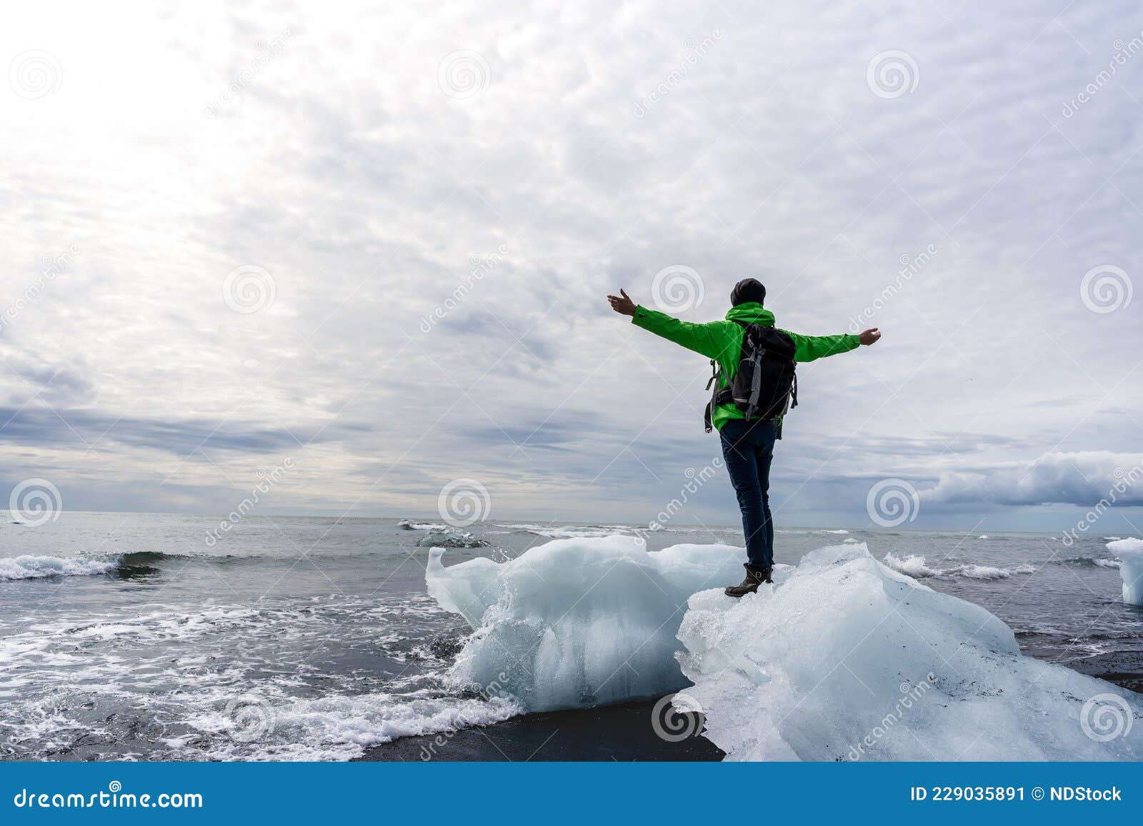 Young Man Standing On A Piece Of Ice Raising His Hands To The Sky Diamond Beach Iceland Stock Image Image Of Outdoors Natural