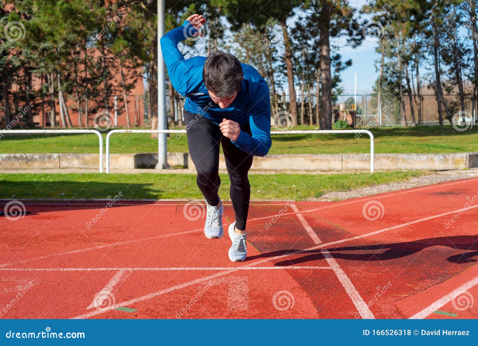 Young Man Starting Sprint on Running Track. Stock Photo - Image of ...