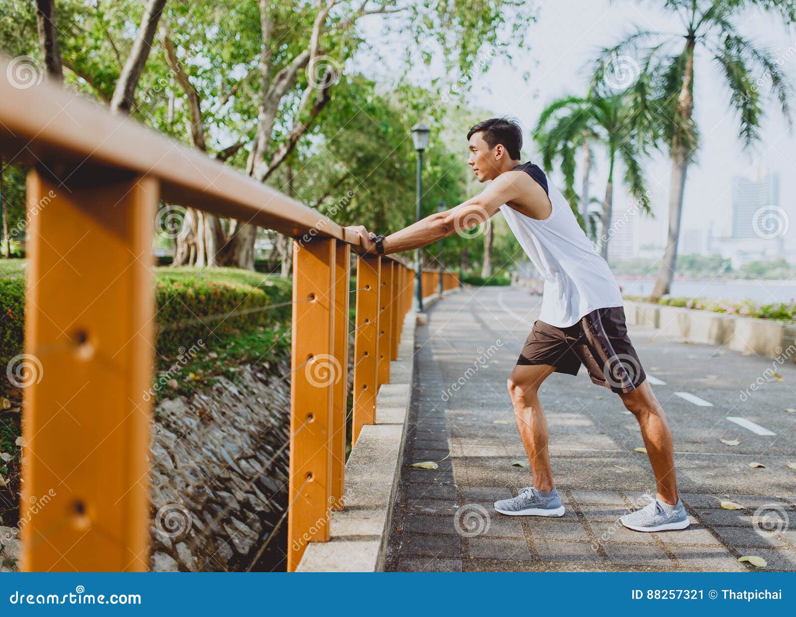 Young Man Stretching Bodies, Warming Up for Jogging in Public Park
