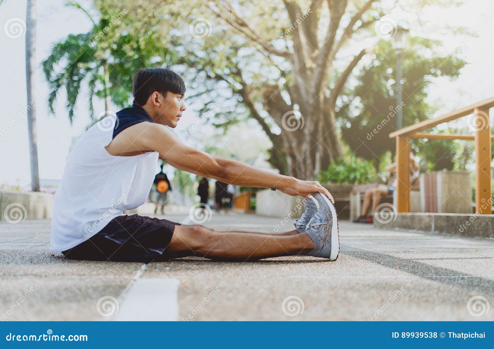 Young Man Stretching Bodies, Warming Up for Jogging in Public Park