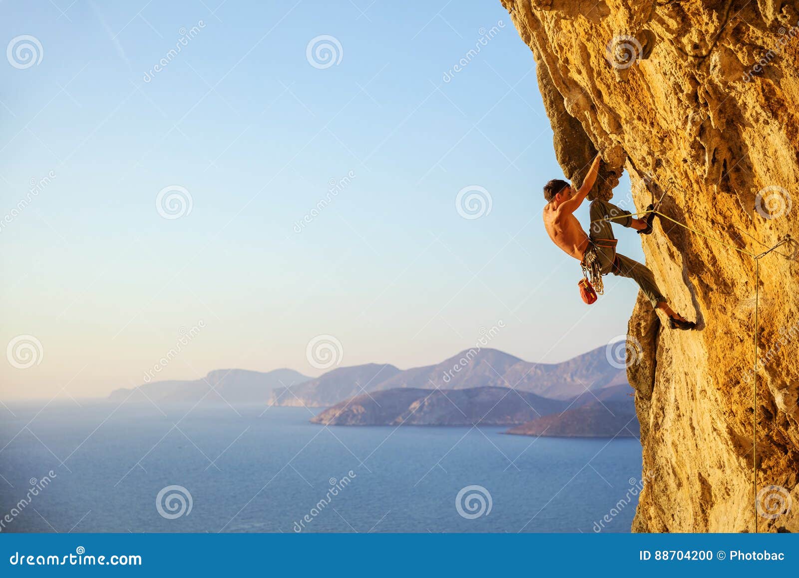 young man struggling to climb challenging route on cliff