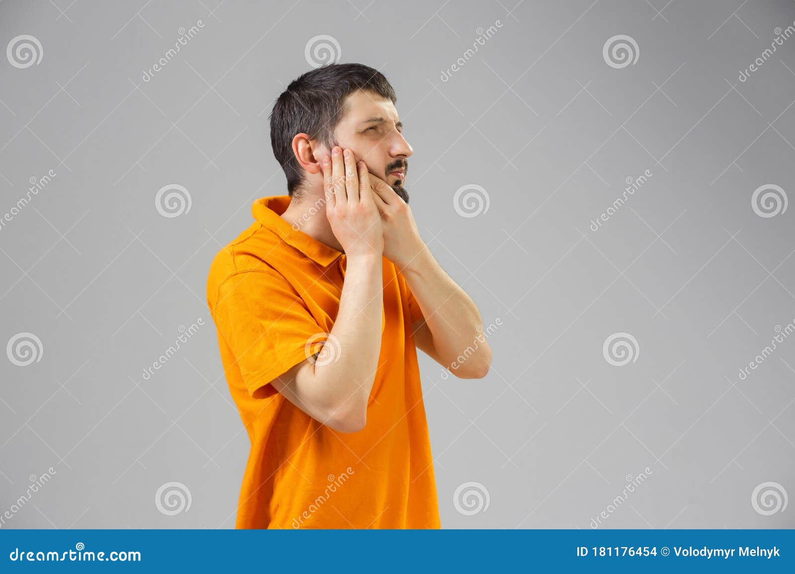 young man suffers from pain, feels sick, ill and weakness isolted on studio background