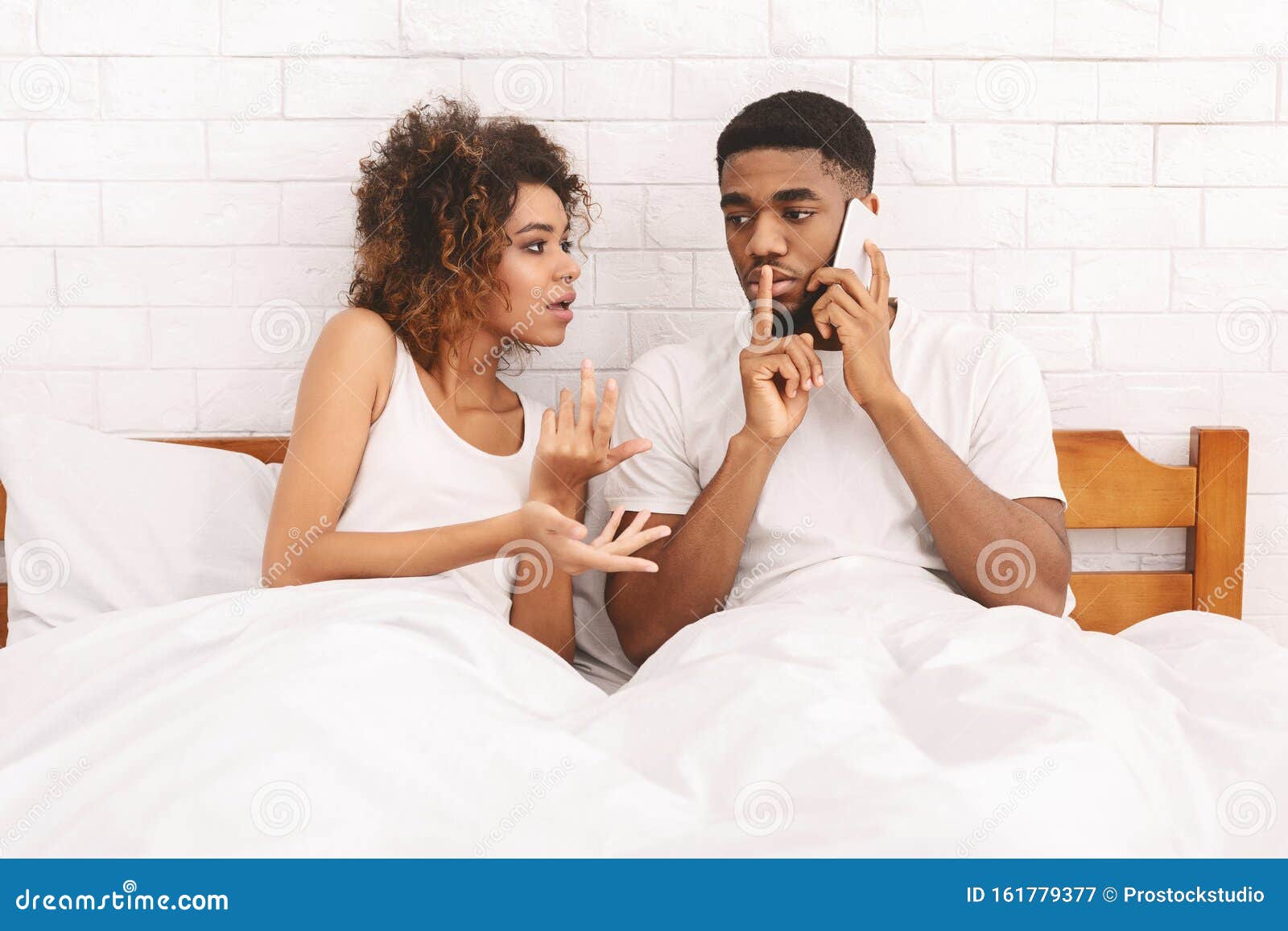 Young Man Talking on Cellphone, Ignoring His Young Hot Wife Stock Image