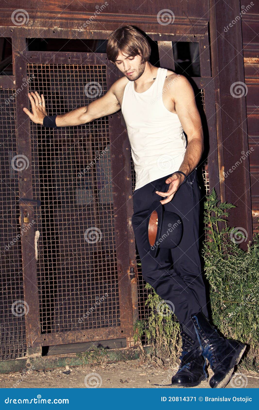 young man in tank top holding hat