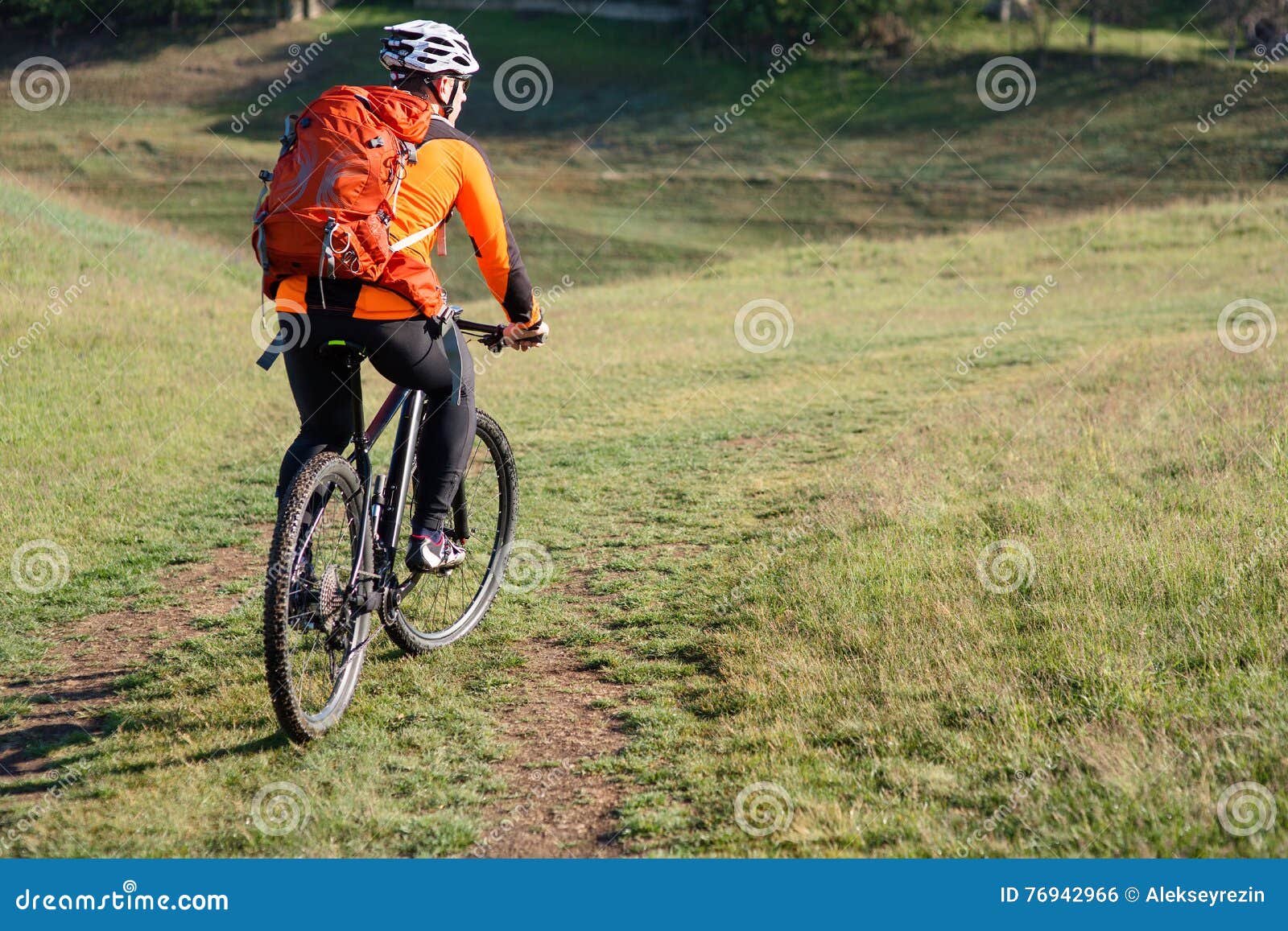 Young Man Traveler Riding on Bicycle with Red Backpack Stock Photo