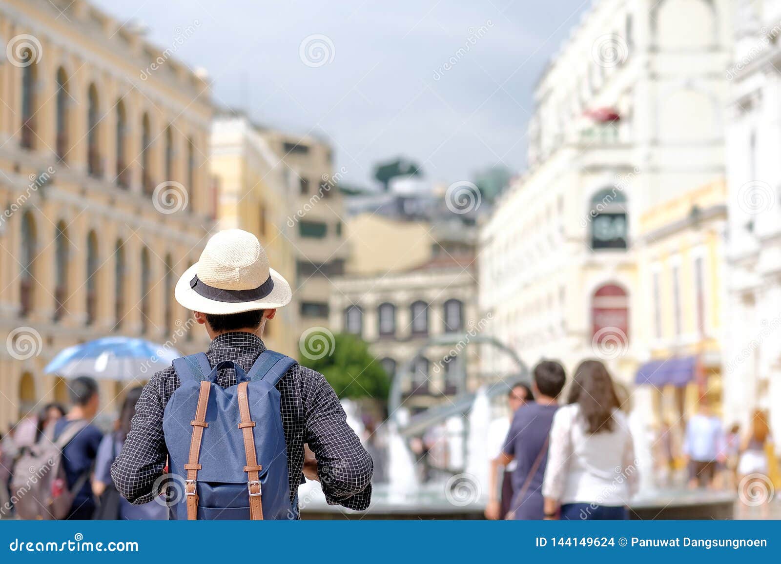 young man traveling backpacker with hat, asian hipster traveler standing on senado square, landmark and popular for tourist attrac