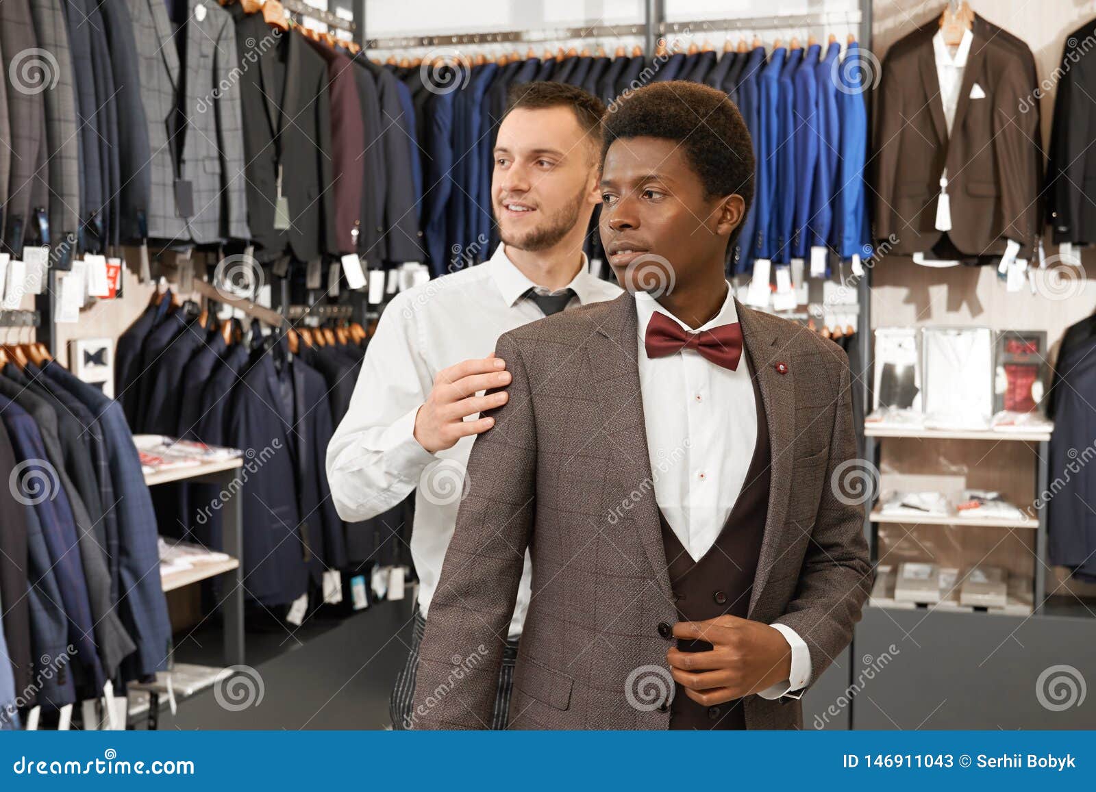 Young Man Trying on and Choosing Suit in Shop. Stock Image - Image of ...
