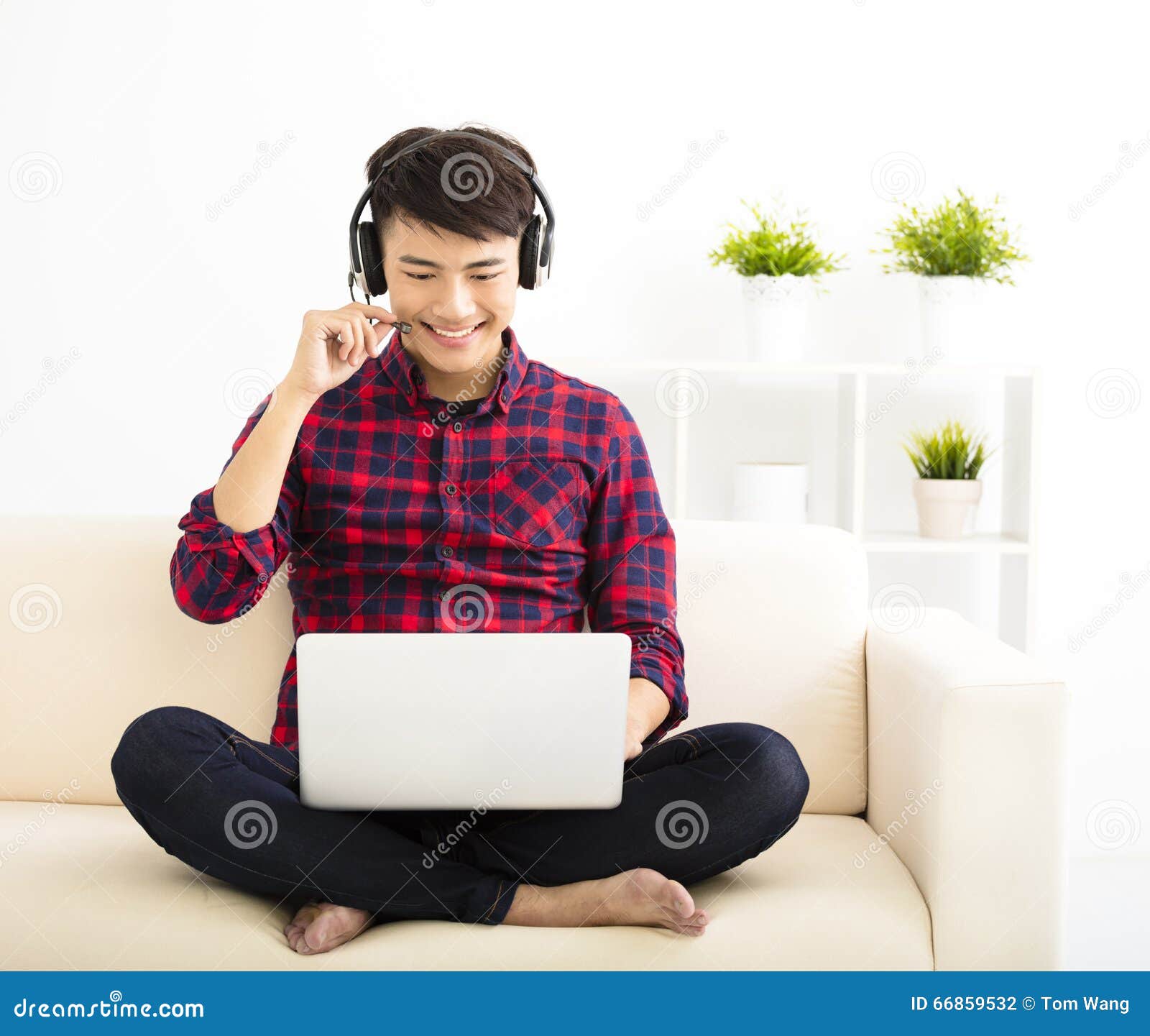 young man using laptop computer with headset
