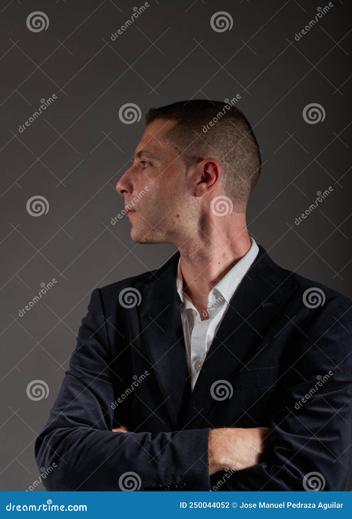 A Young Man Wearing a White Shirt and a Black Jacket Stock Photo