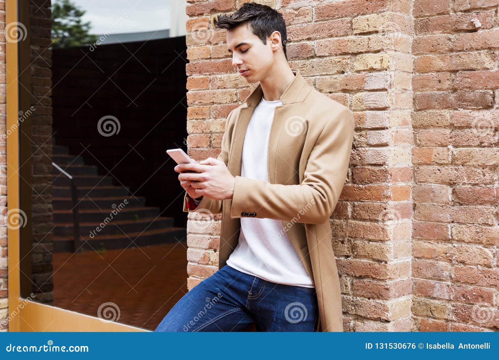 Young Man Wearing Winter Clothes in the Street Using the Phone. Young Guy with Modern Hairstyle with Coat, Blue Jeans and T-shirt Stock Photo - Image of elegant, coat: 131530676 Young Man Wearing Winter Clothes in the Street Using the Phone. Young Guy with Modern Hairstyle with Coat, Blue Jeans and T-shirt Stock Photo - Image of elegant, coat: 131530676