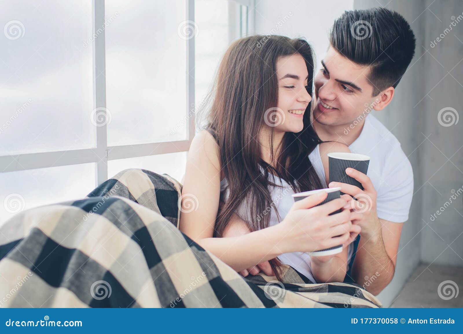 A Young Man and a Woman are Drinking Coffee in the Morning in Bed ...
