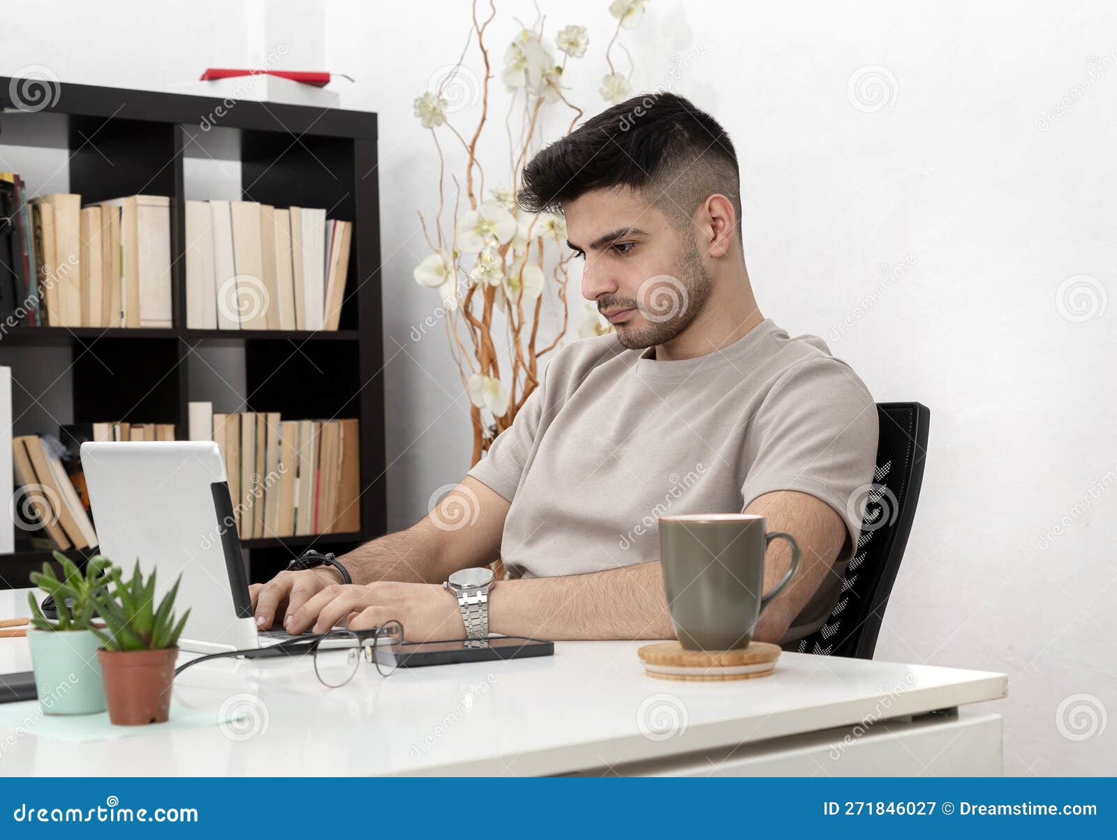Young Man Working on Computer in Home Office.education.business.e
