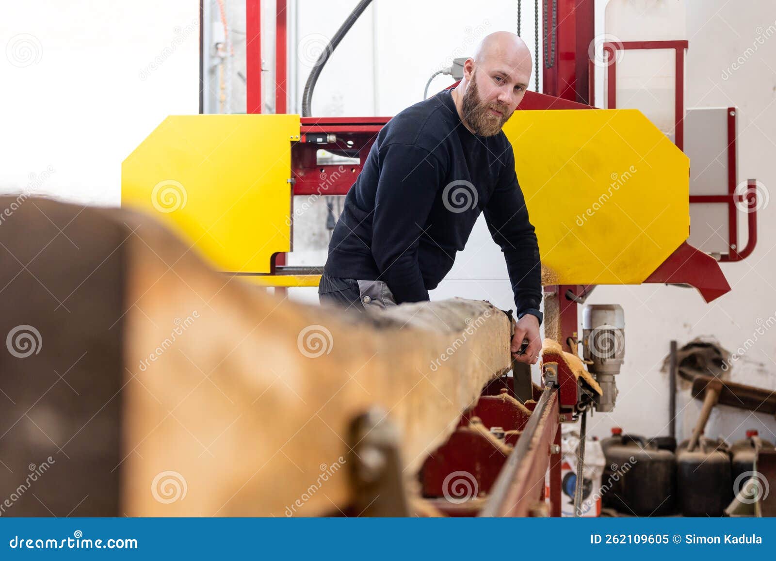 Young Man Working on the Machine for Processing the Wood, Huge Wood