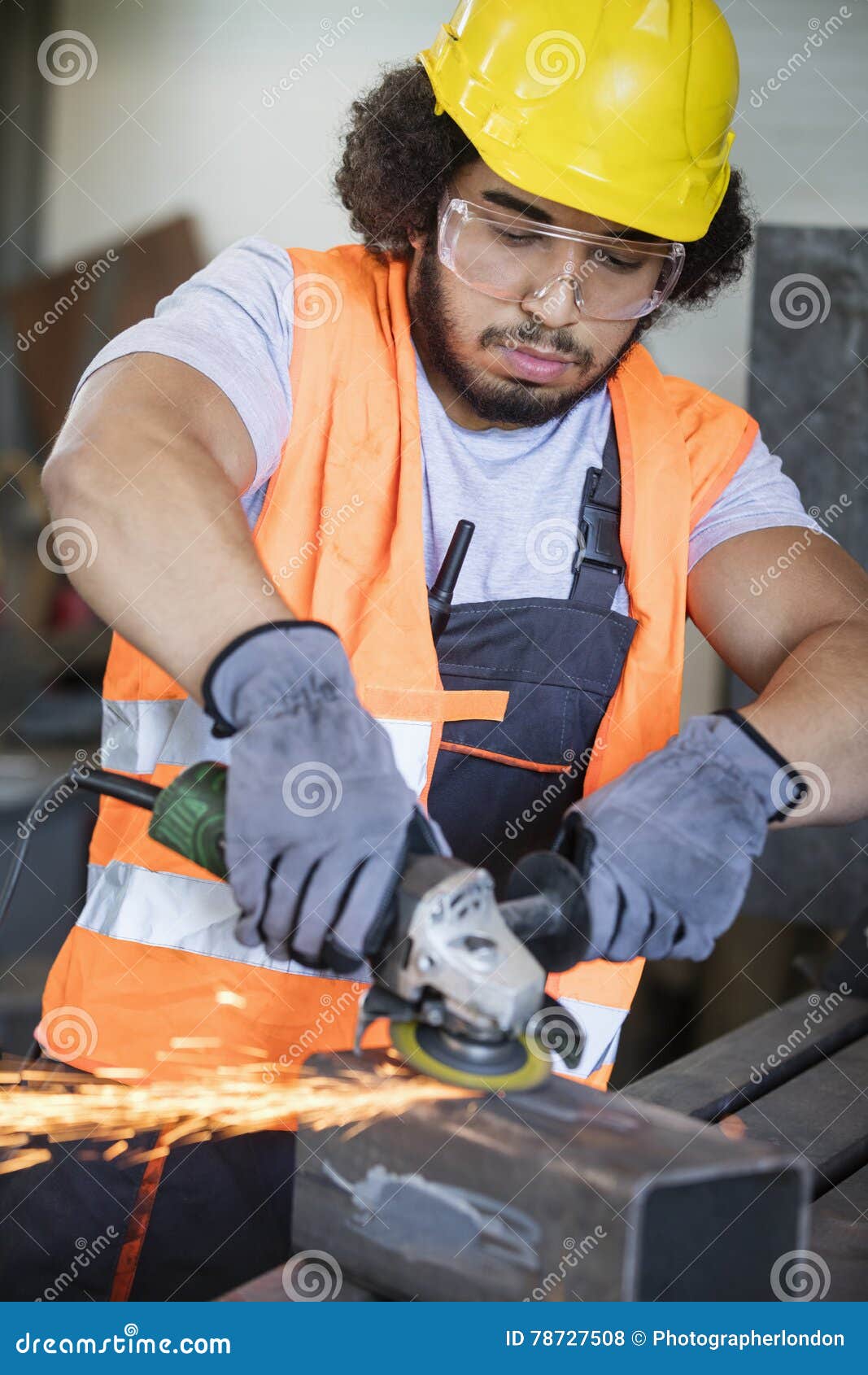 young manual worker grinding metal in industry