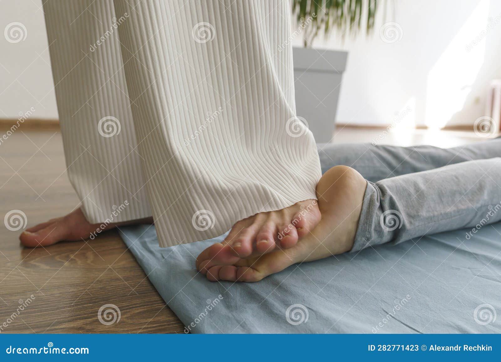 Young Masseuse Does A Thai Massage On The Floor To A Girl Massaging Her Feet Stock Image Image