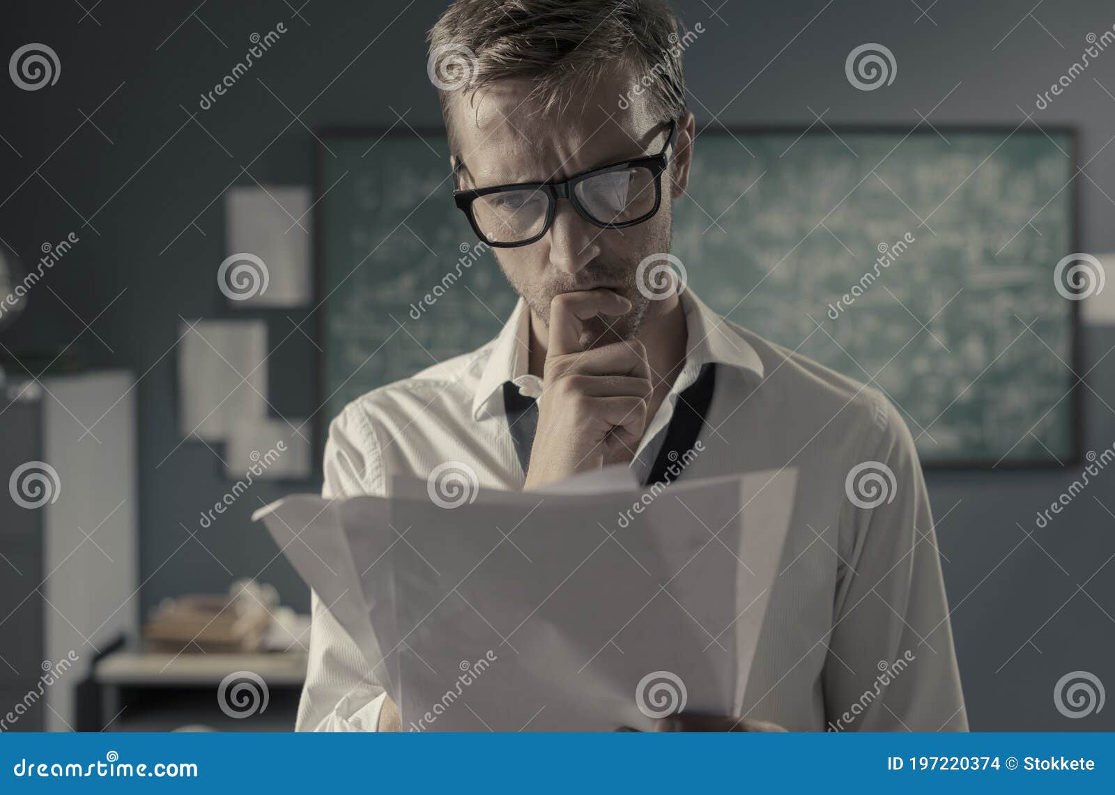 young mathematician studying in his office and reading papers