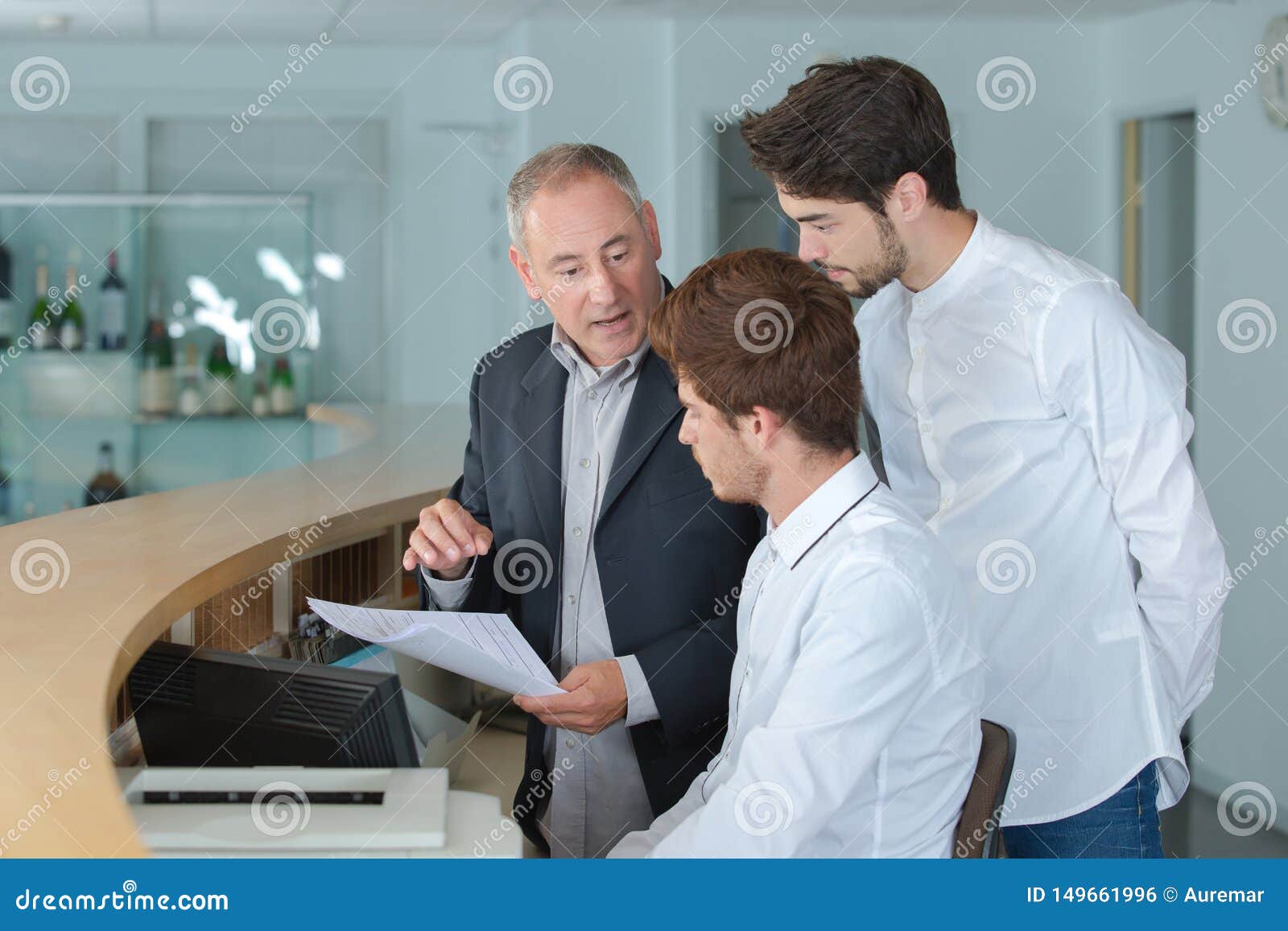 Young Men Being Trained At Reception Desk Stock Photo Image Of