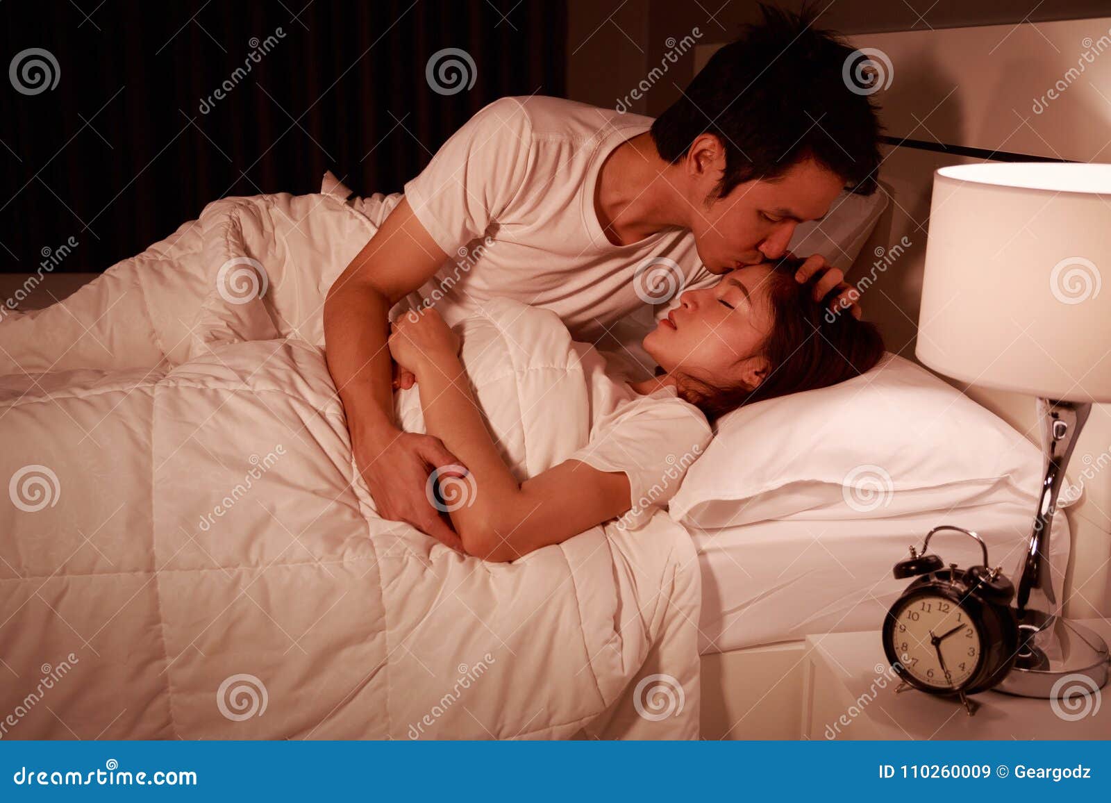 Man Kissing His Wife in Bed at Night Stock Image - Image of clock ...