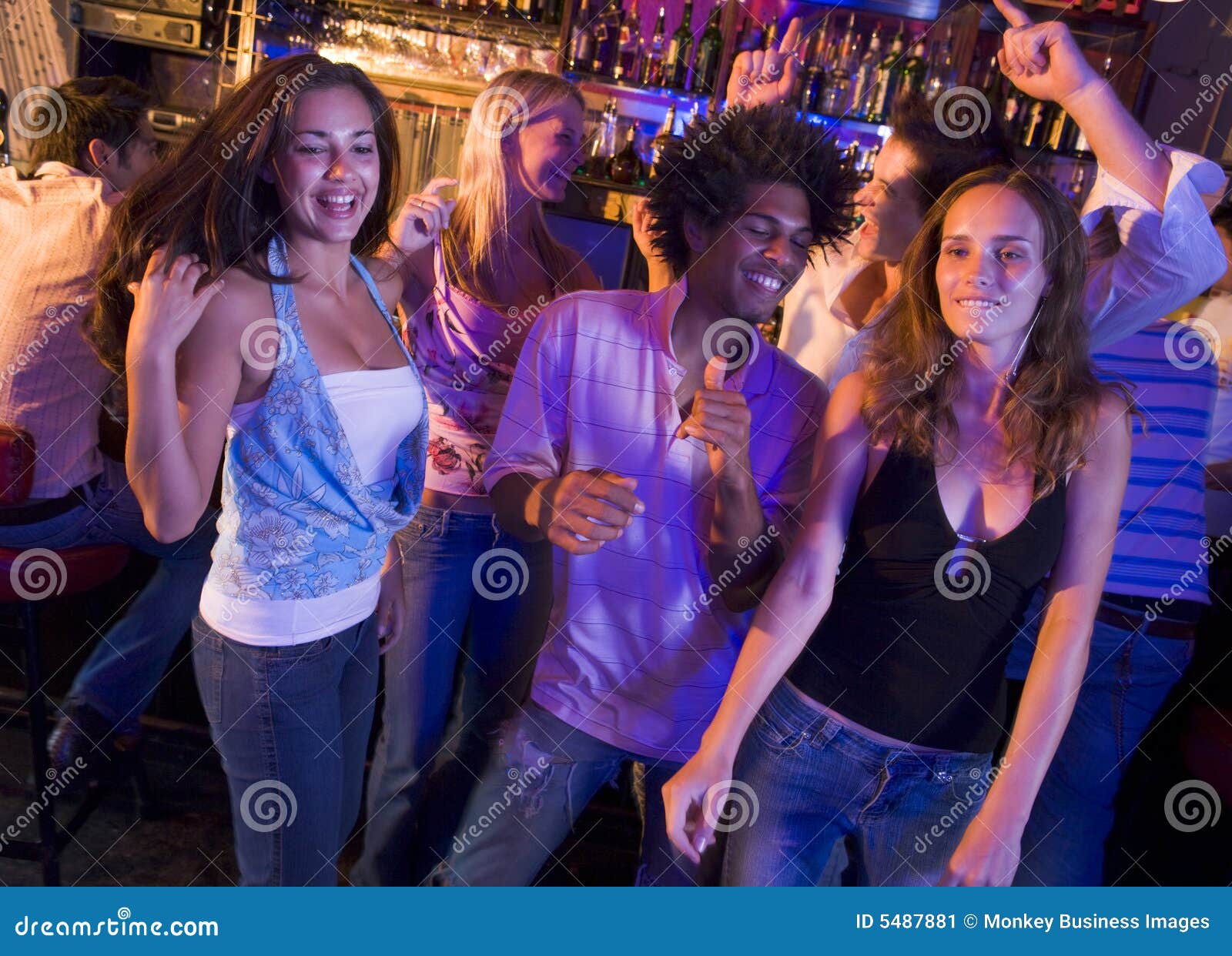 young men and women dancing in a nightclub