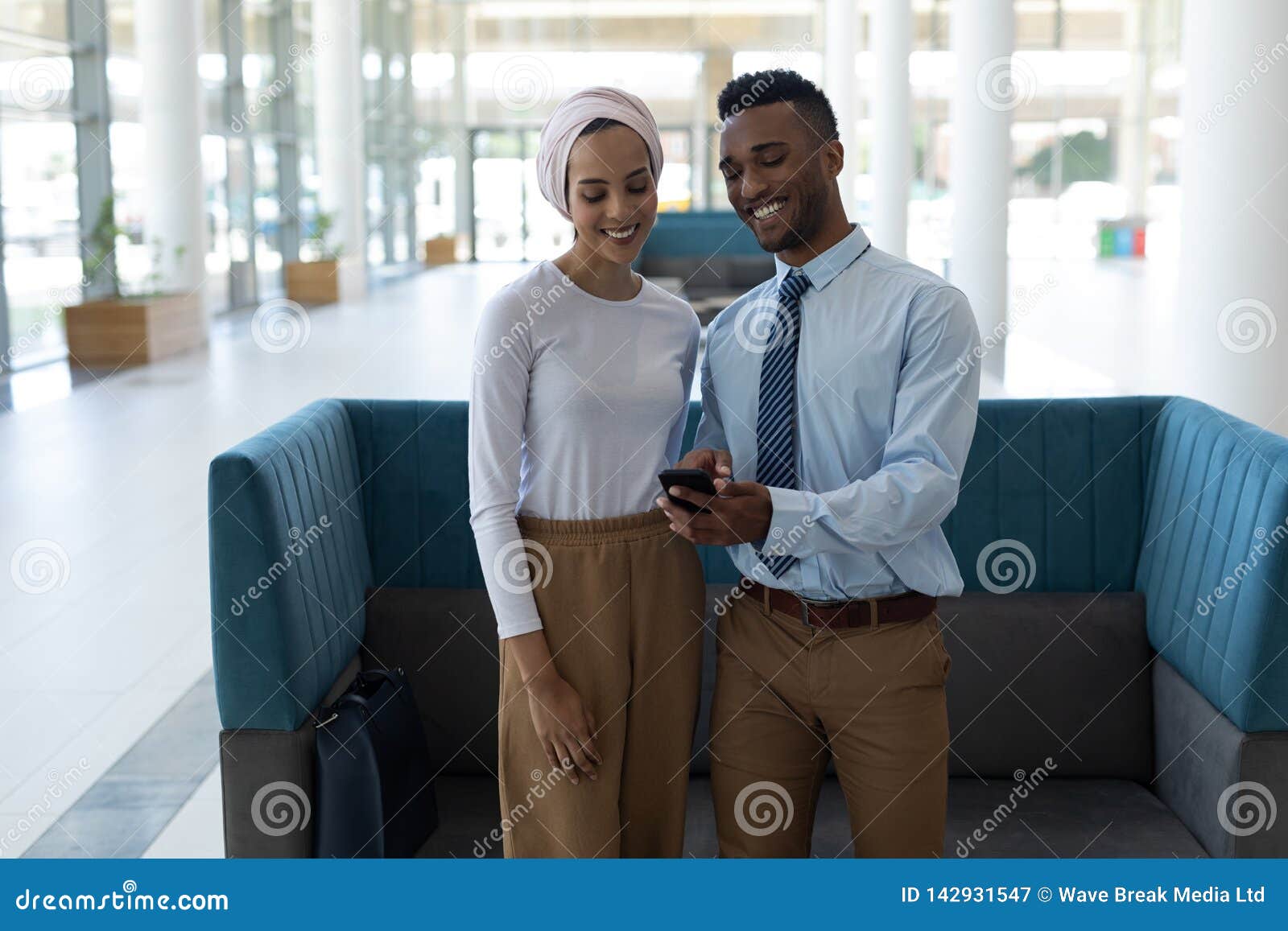 Young Mixedrace Couple Using Mobile Phone In The
