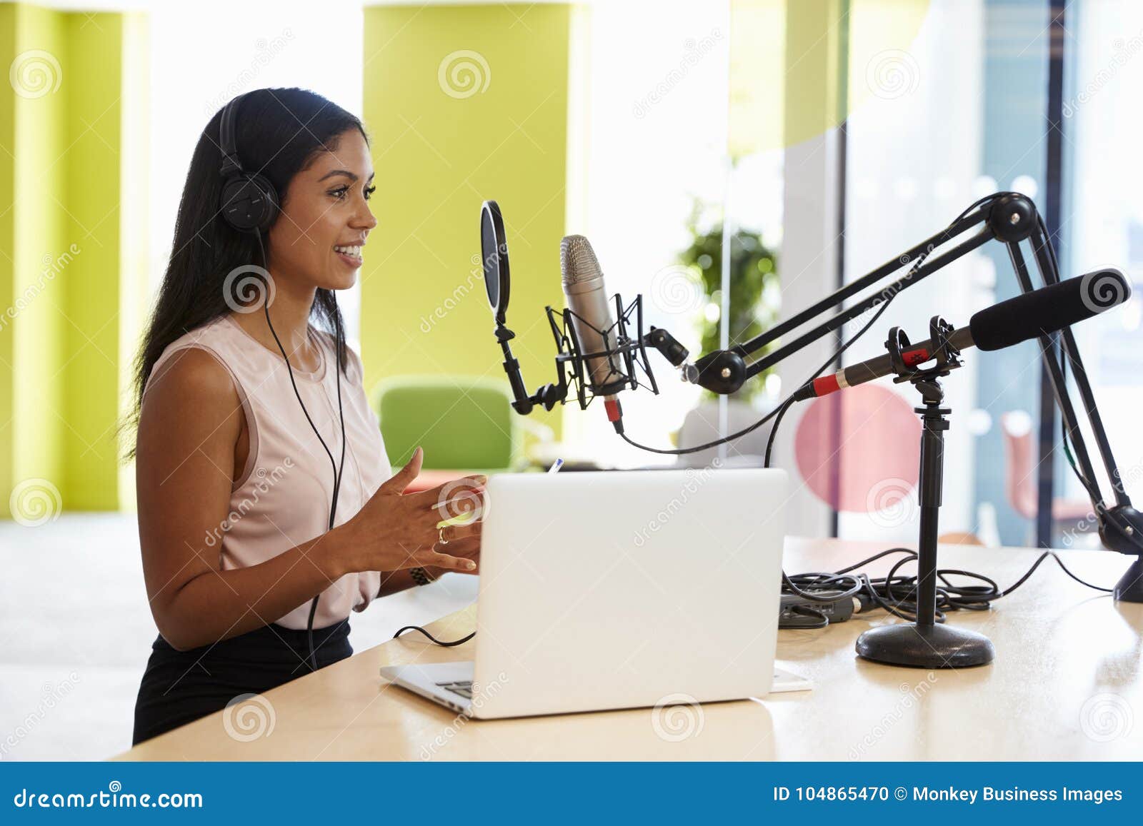 young mixed race woman recording a podcast in a studio