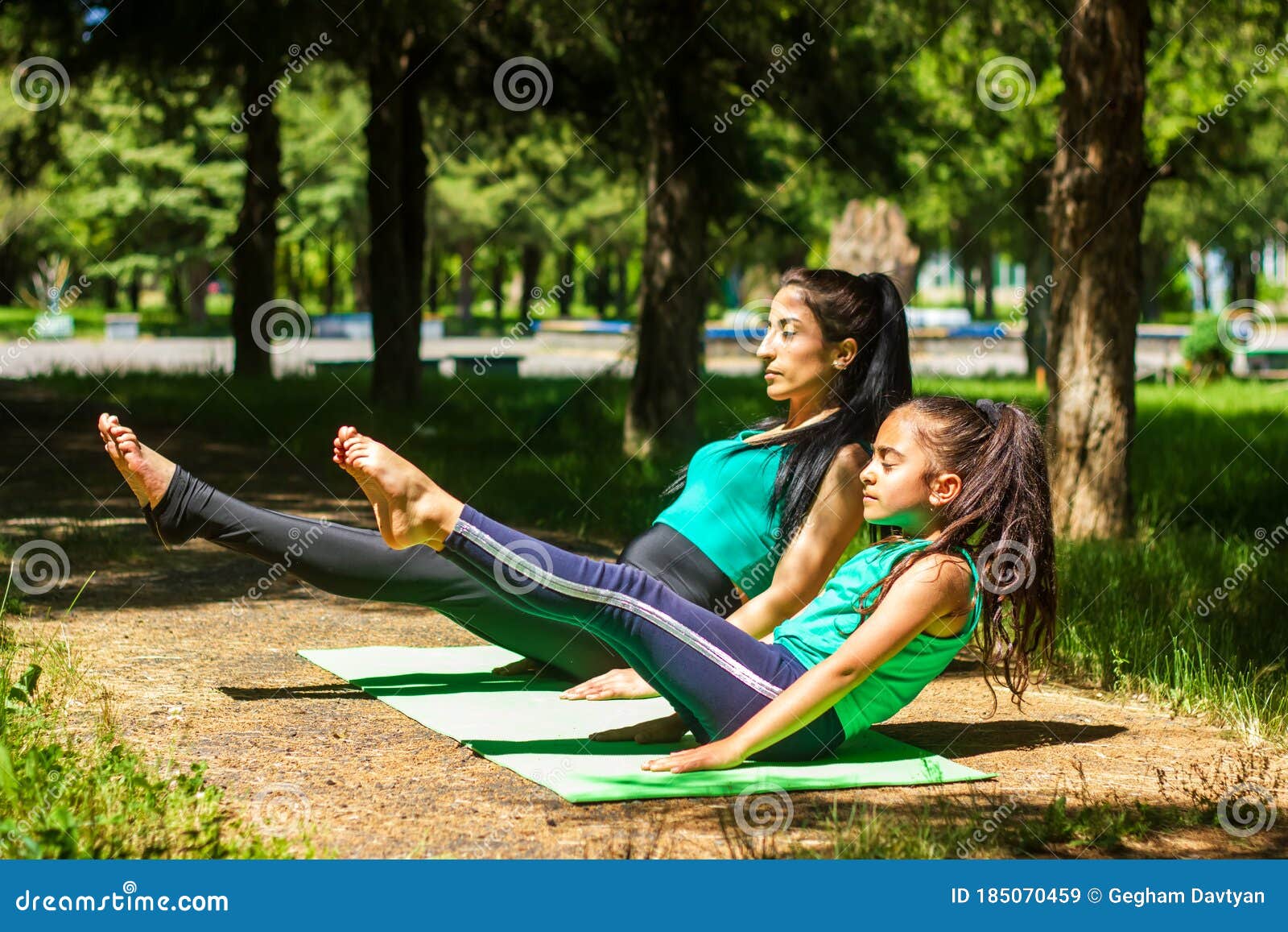 Young Mother And Daughter Doing Yoga Exercises Young Woman Doing Yoga