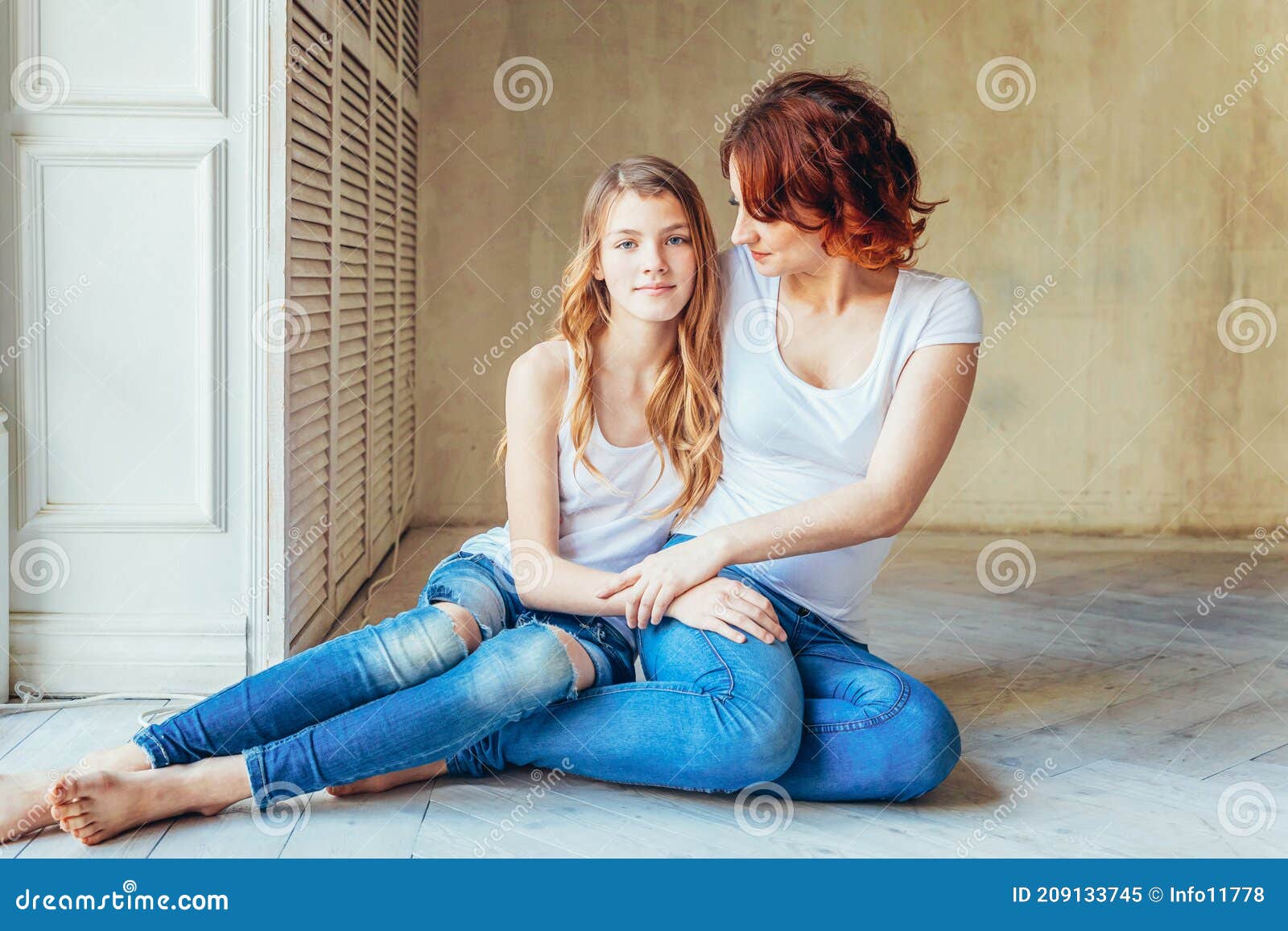 Young Mother Embracing Her Child. Woman and Teenage Girl Relaxing in