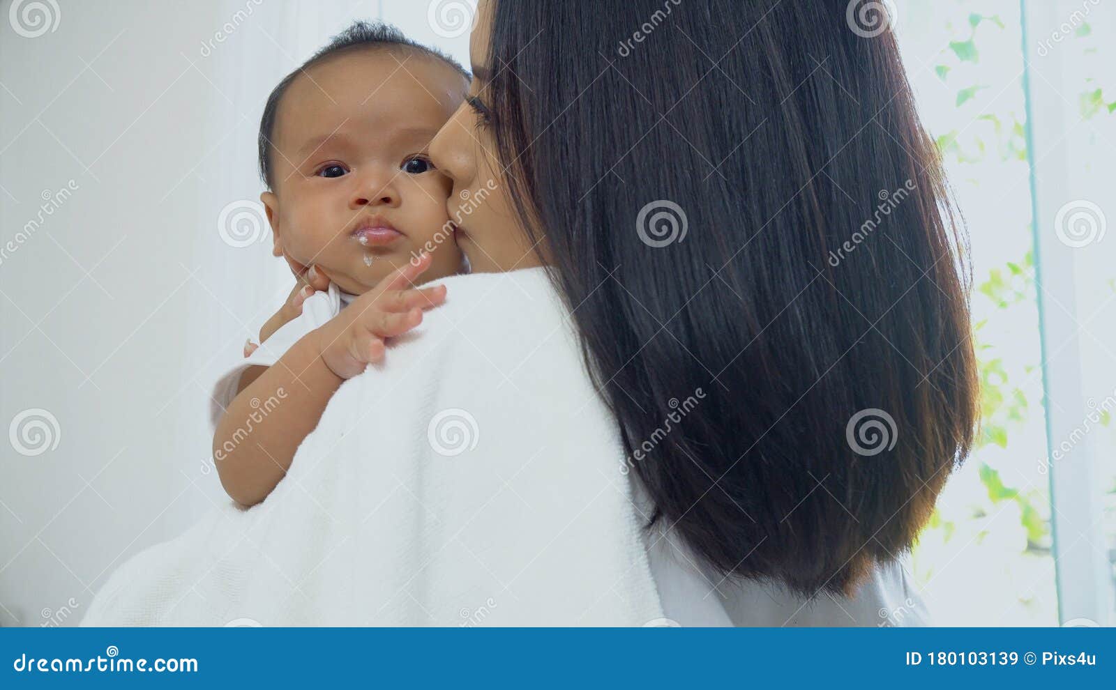 young mother kissing on cheek baby