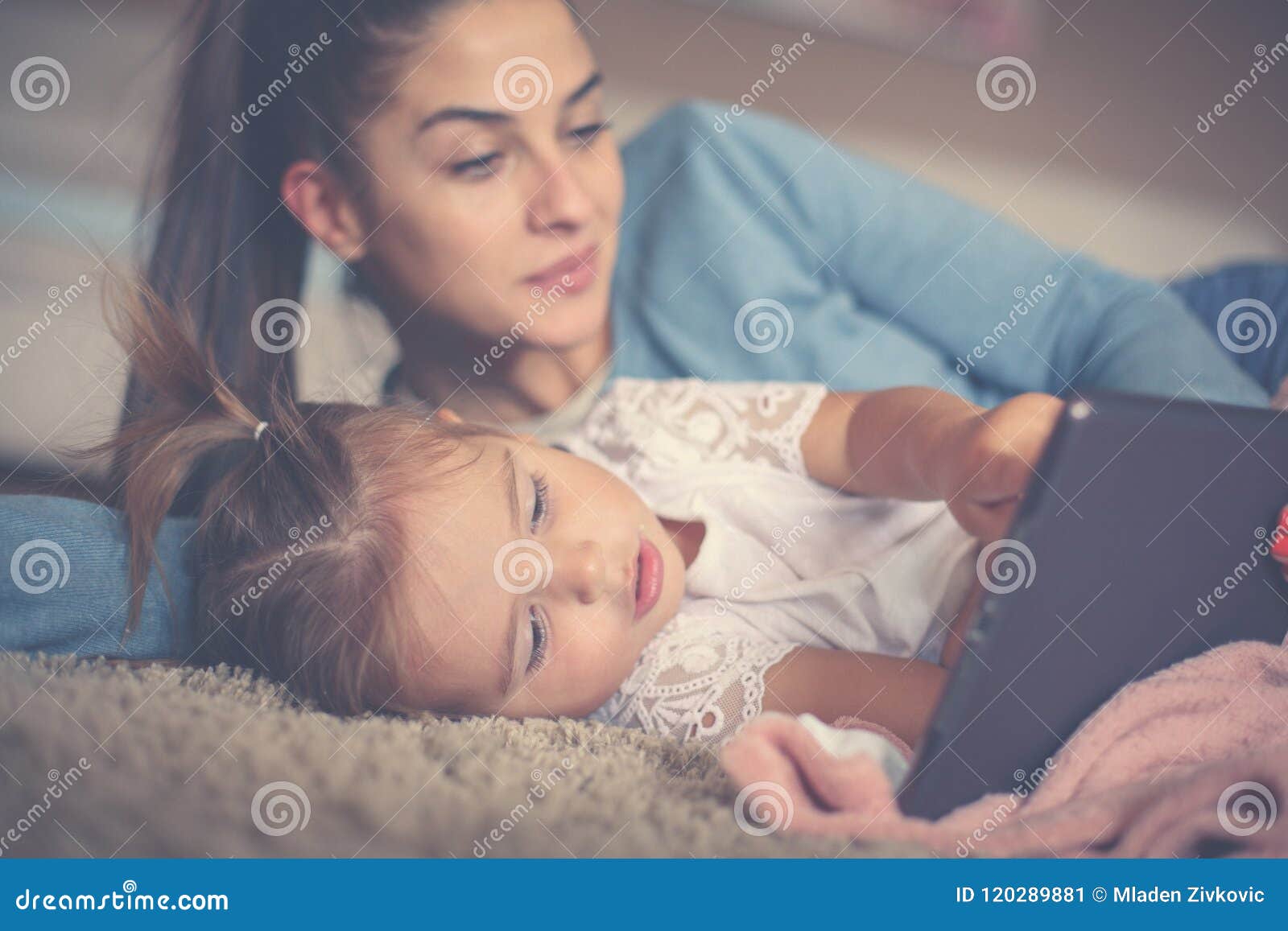 mother and little girl enjoying at home and using ipod. cl