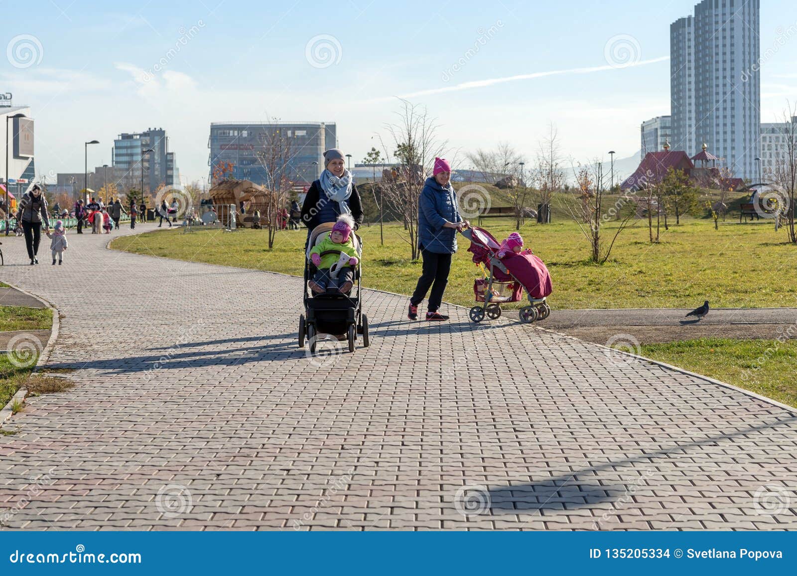 Young Mothers Walk with Small Children in a Public Garden, on the Background  of the Krasnoyarsk City Editorial Stock Image - Image of mother, baby:  135205334