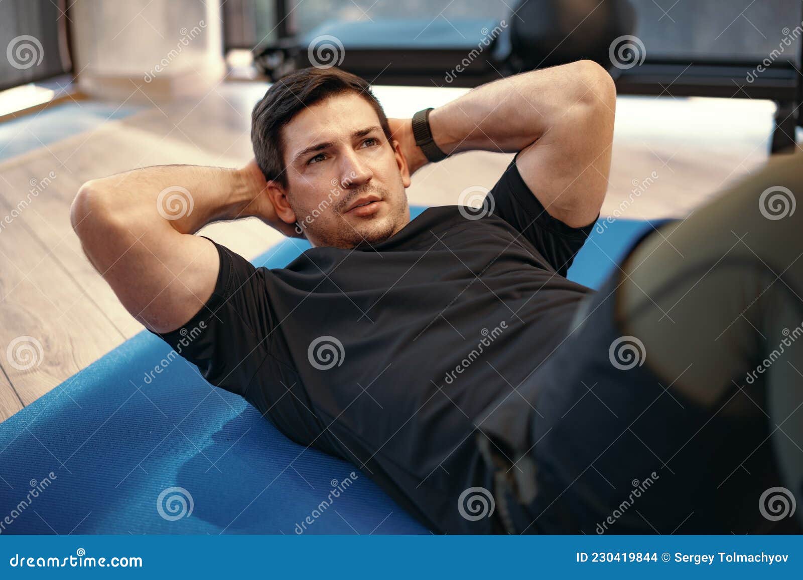 Young Muscular Caucasian Handsome Man Doing Abs Exercises on Mat Stock