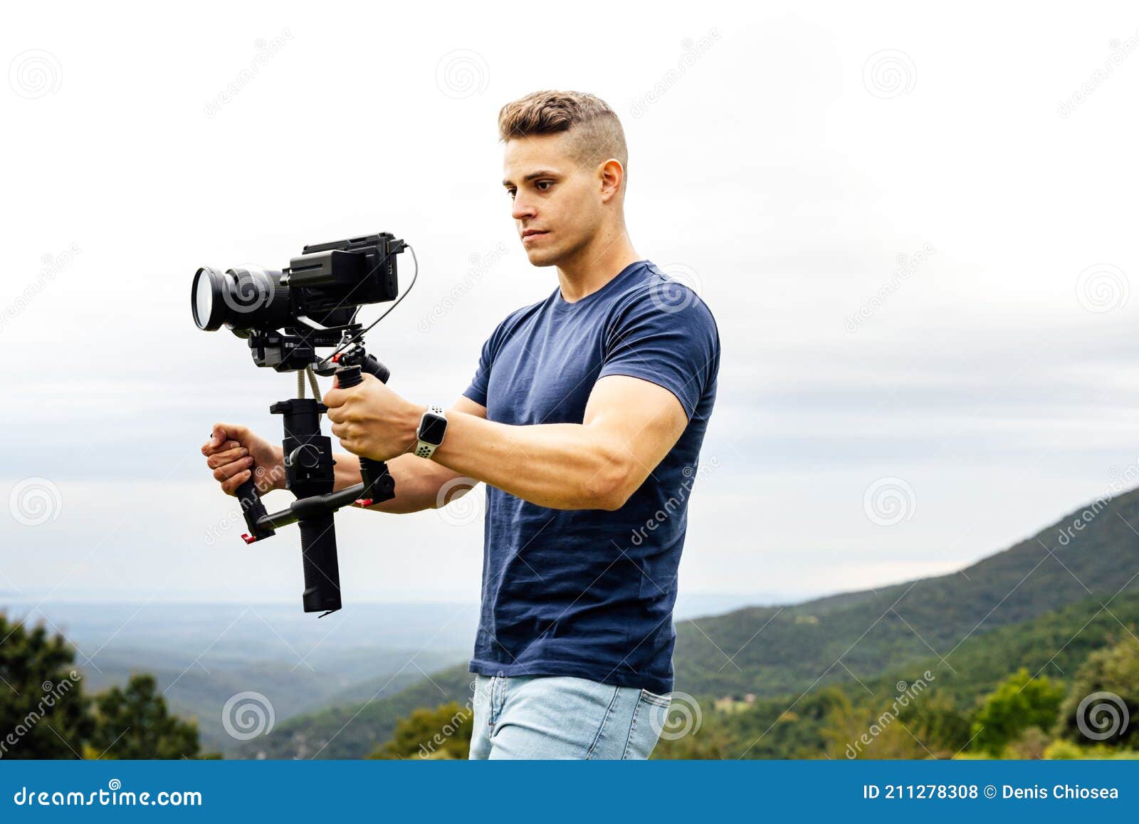 young caucasian man handling a camera on top of a gimbal while working on recording a scene