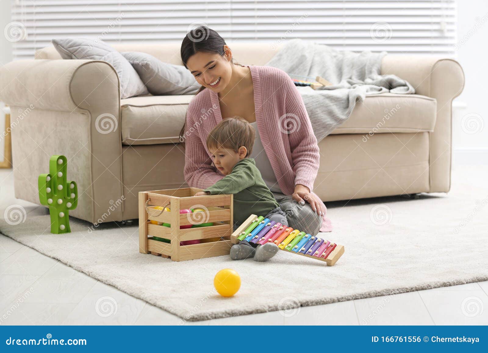young nanny and cute little baby playing with toys