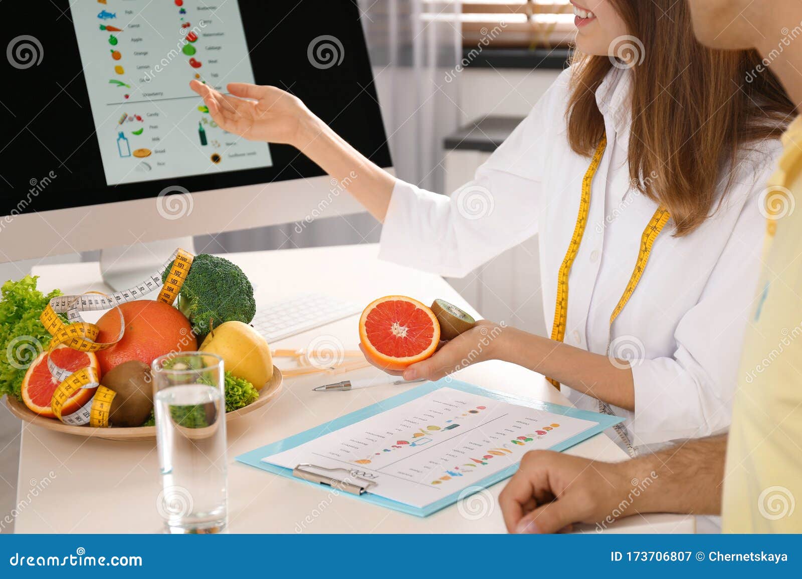 young nutritionist consulting patient at table in clinic