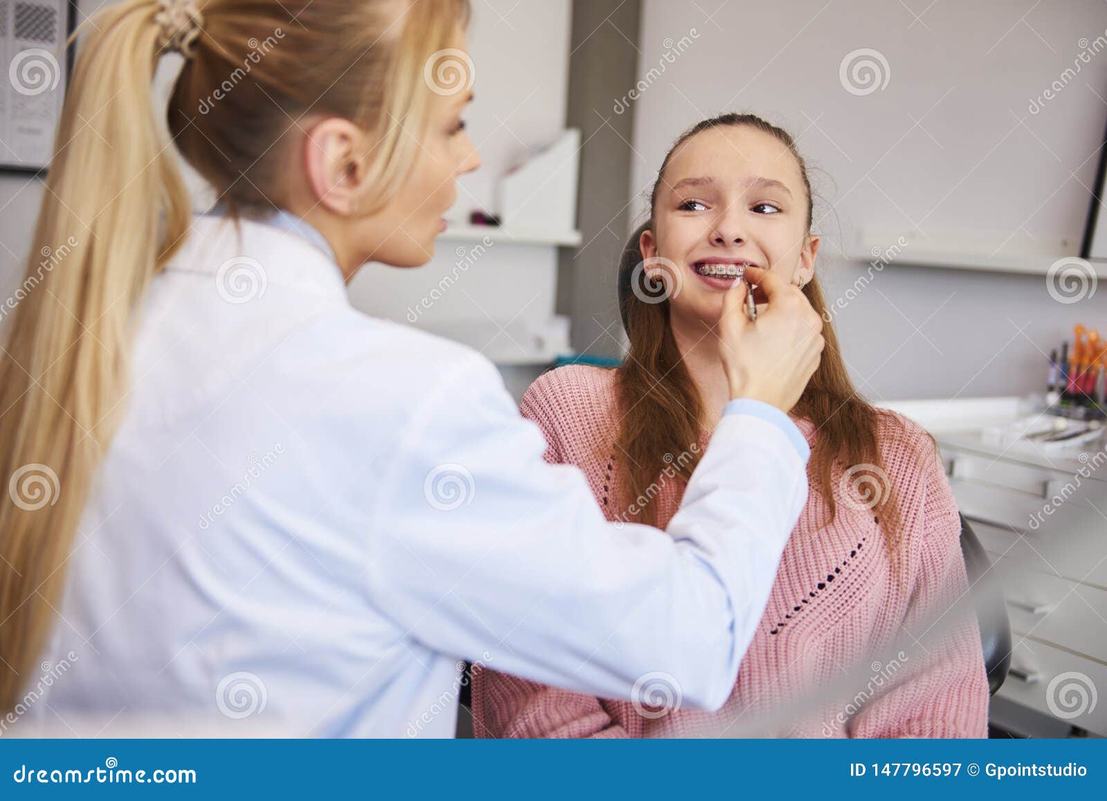 young orthodontist checking patient in dentist`s office