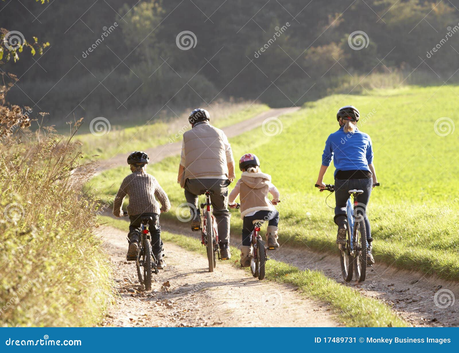 young parents with children ride bikes in park
