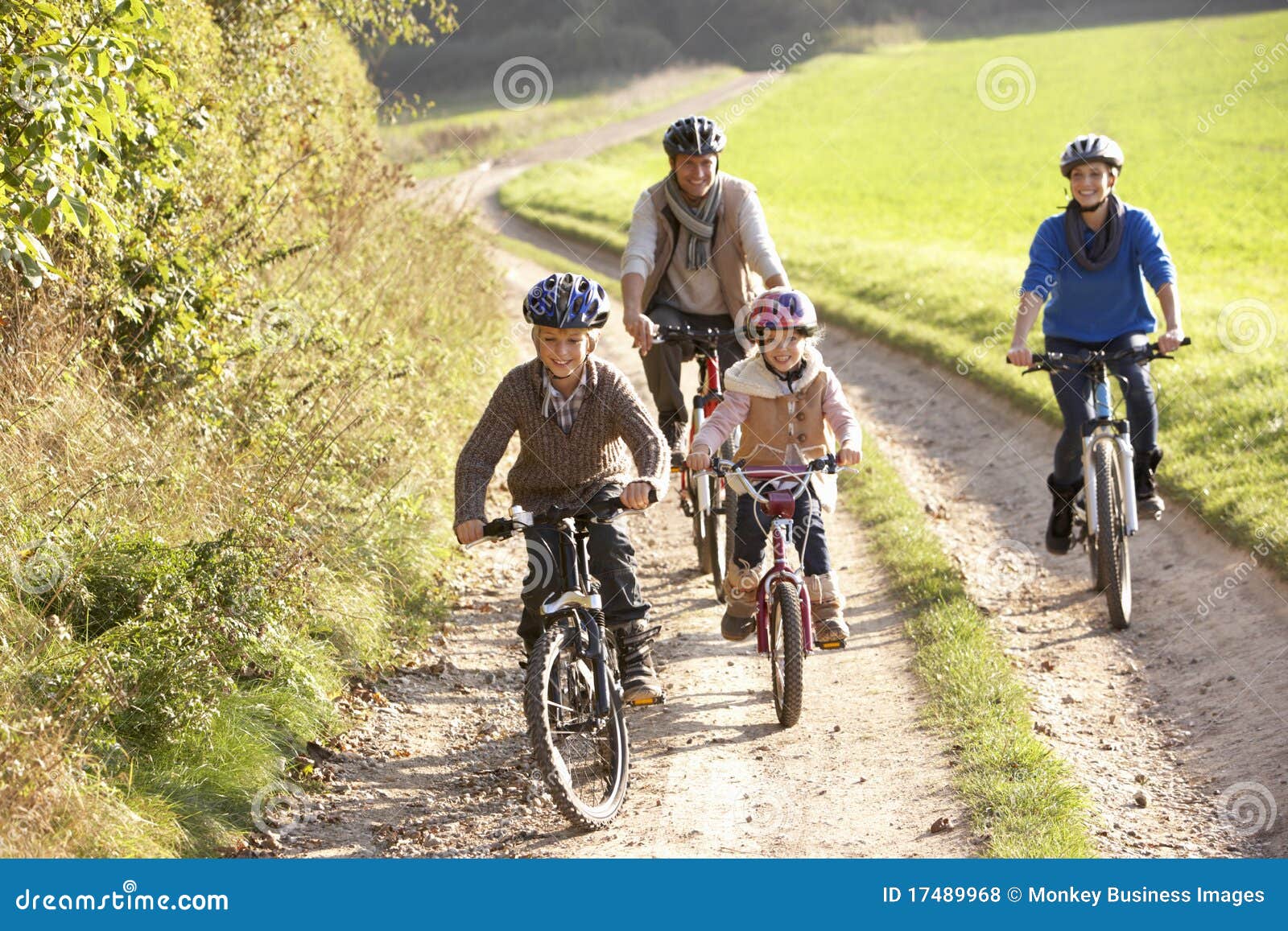 young parents with children ride bikes in park