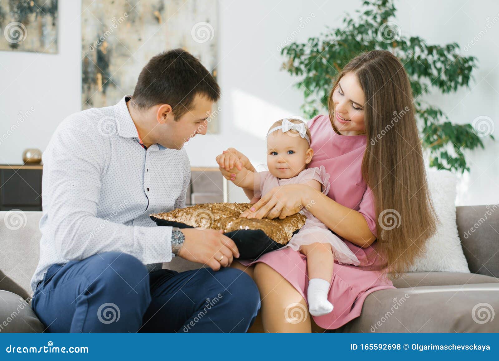 young parents mom dad play their one year old daughter living room home 165592698