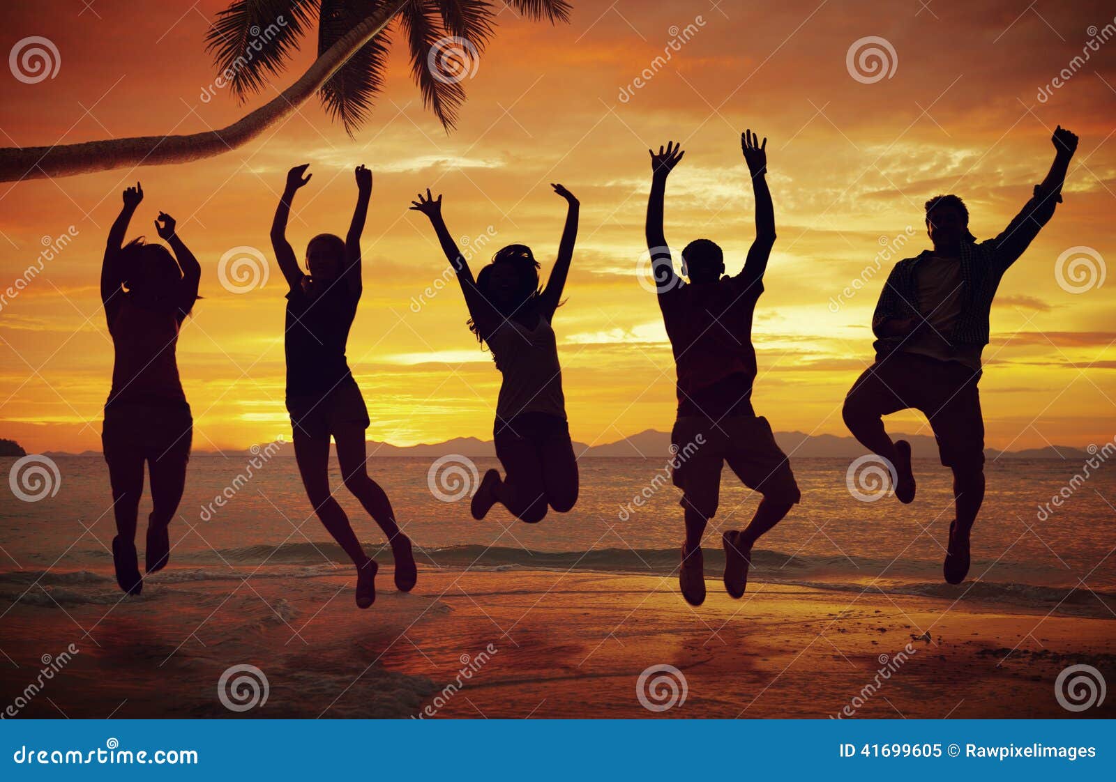 young people jumping with excitement on the beach