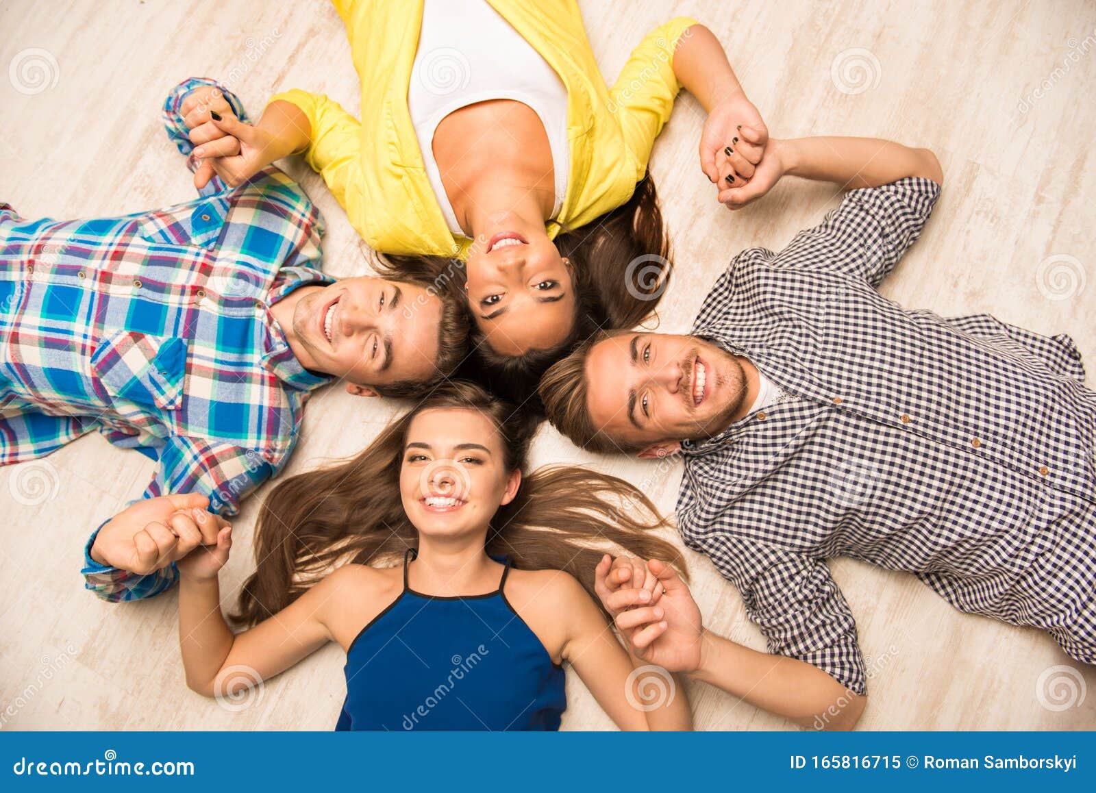 Young People Lying On The Floor Holding Hands Stock Image Image