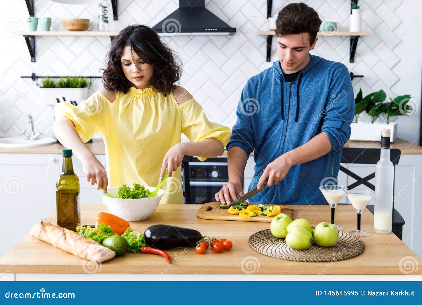 Young Cute Smiling Couple Cooking Together At Kitchen At Home Young