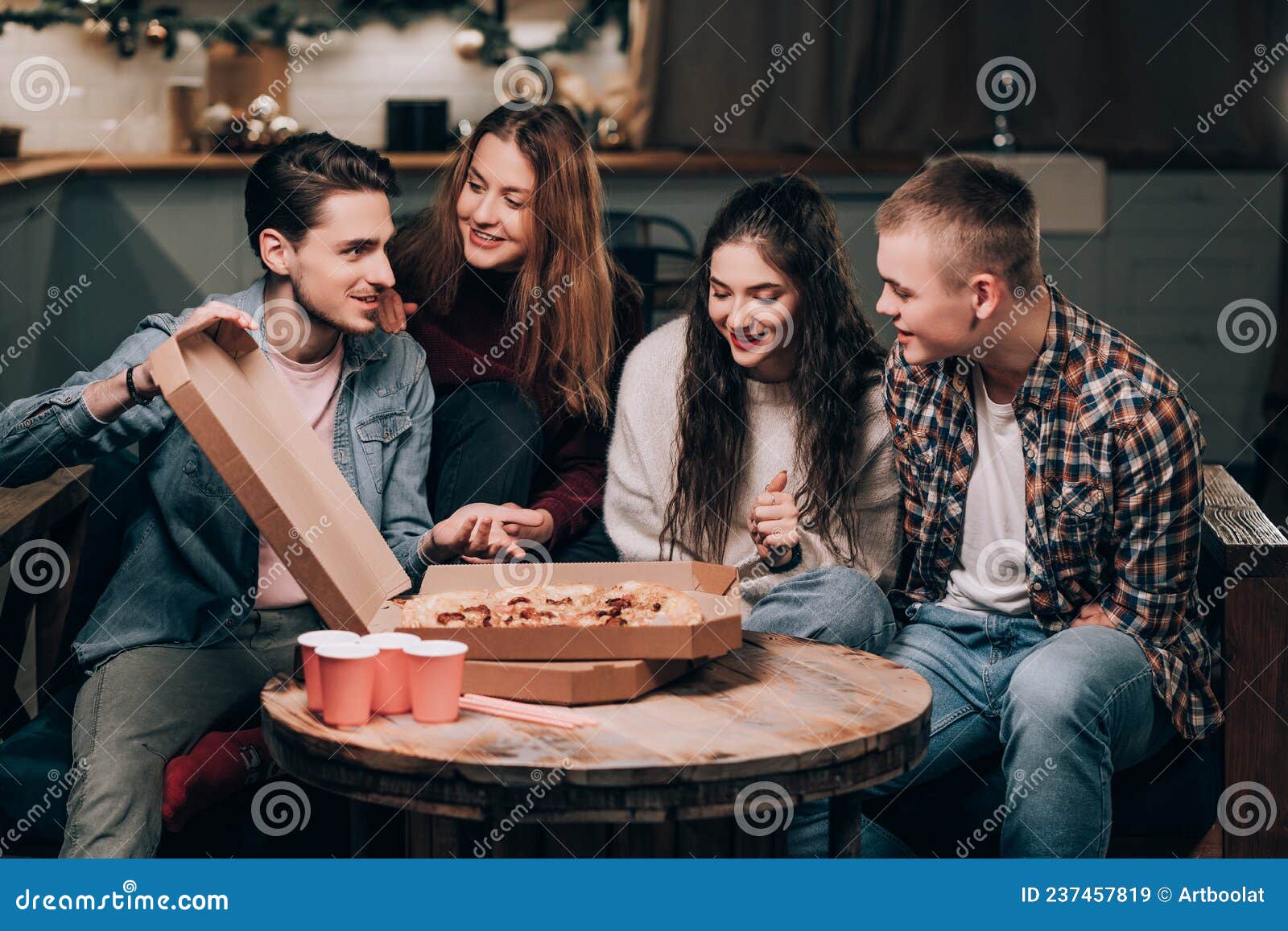 young people socialize at a non-alcoholic pizza party in the living room