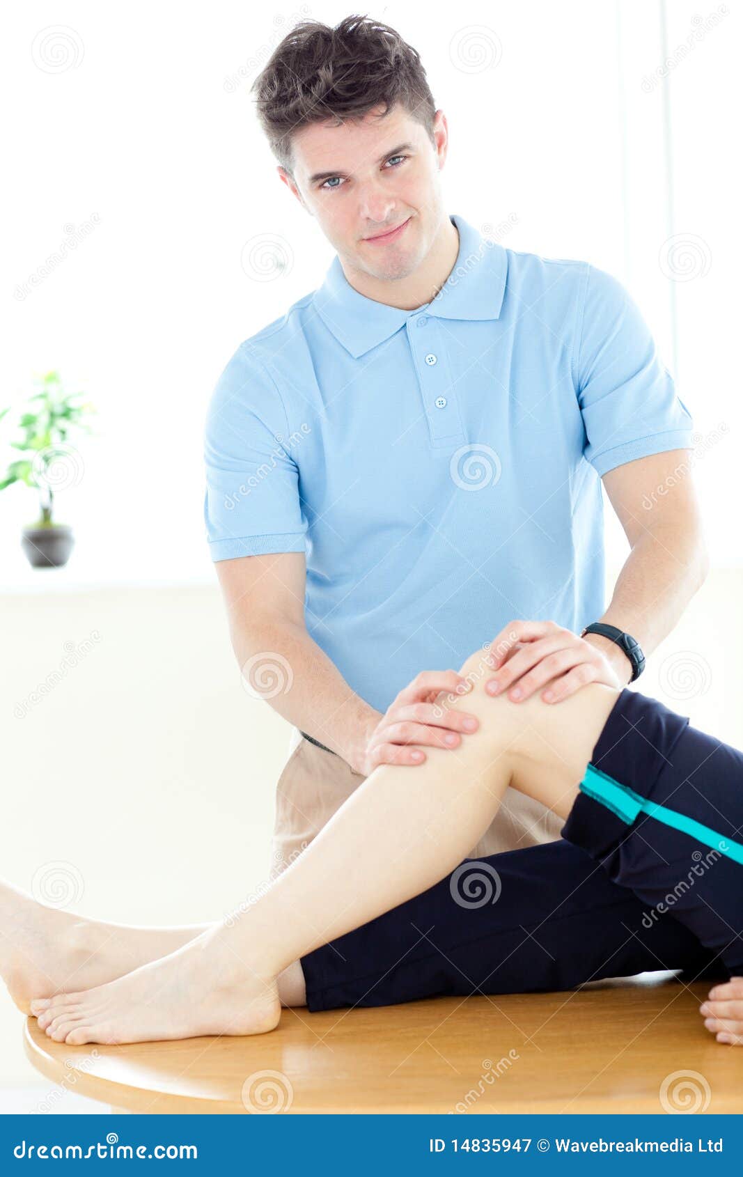 young physical therapist giving a leg massage