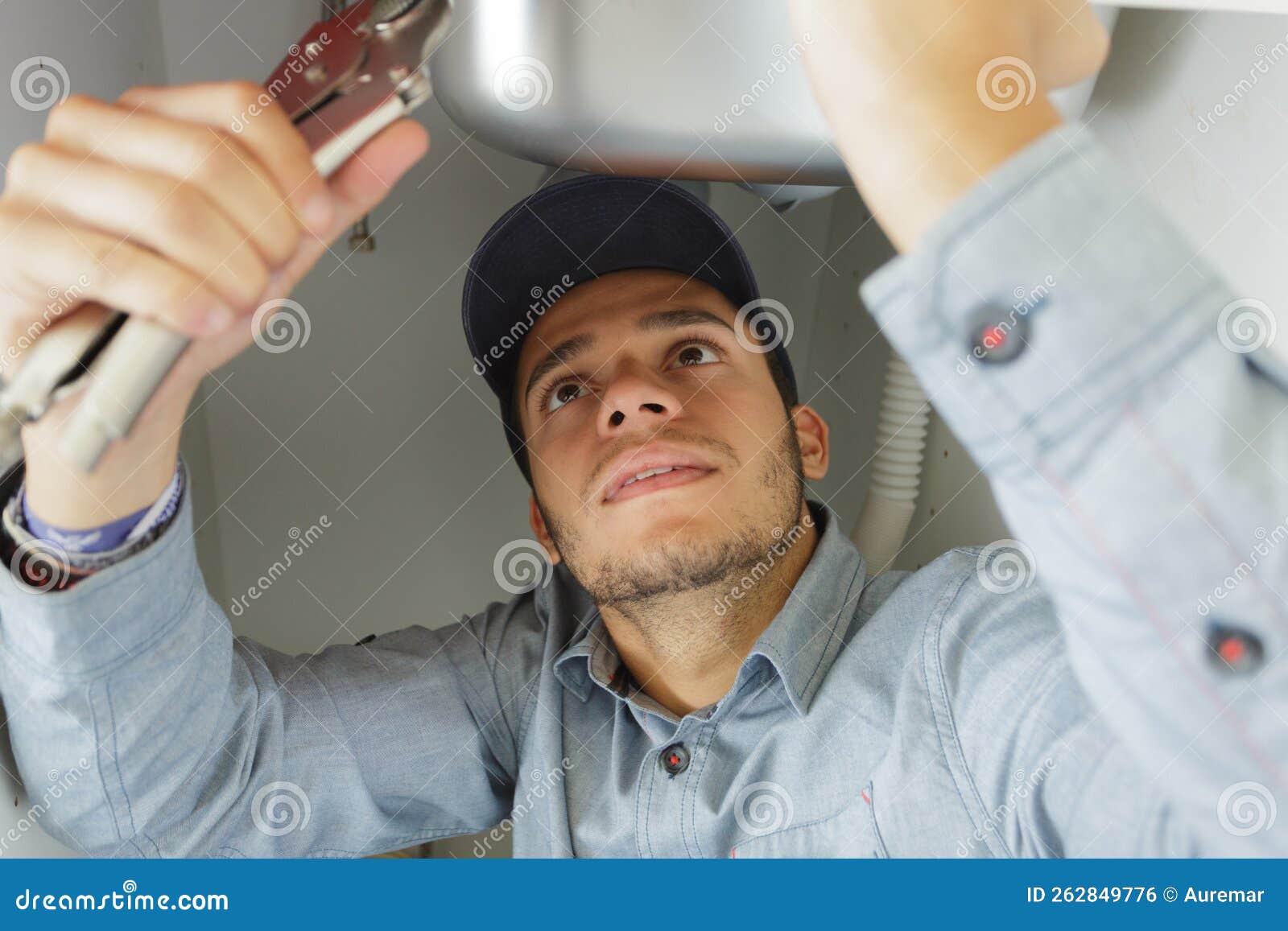 Young Plumber Using Wrench Under Sink Stock Photo Image of handyman
