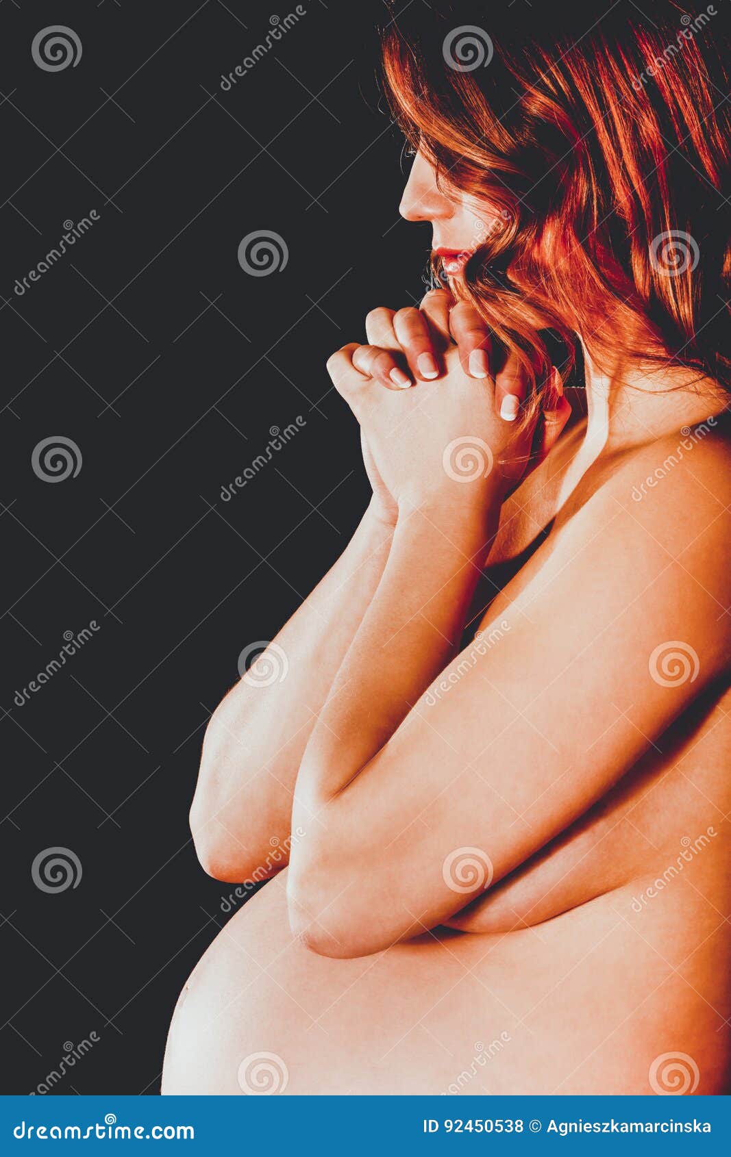 Young pregnant woman praying.