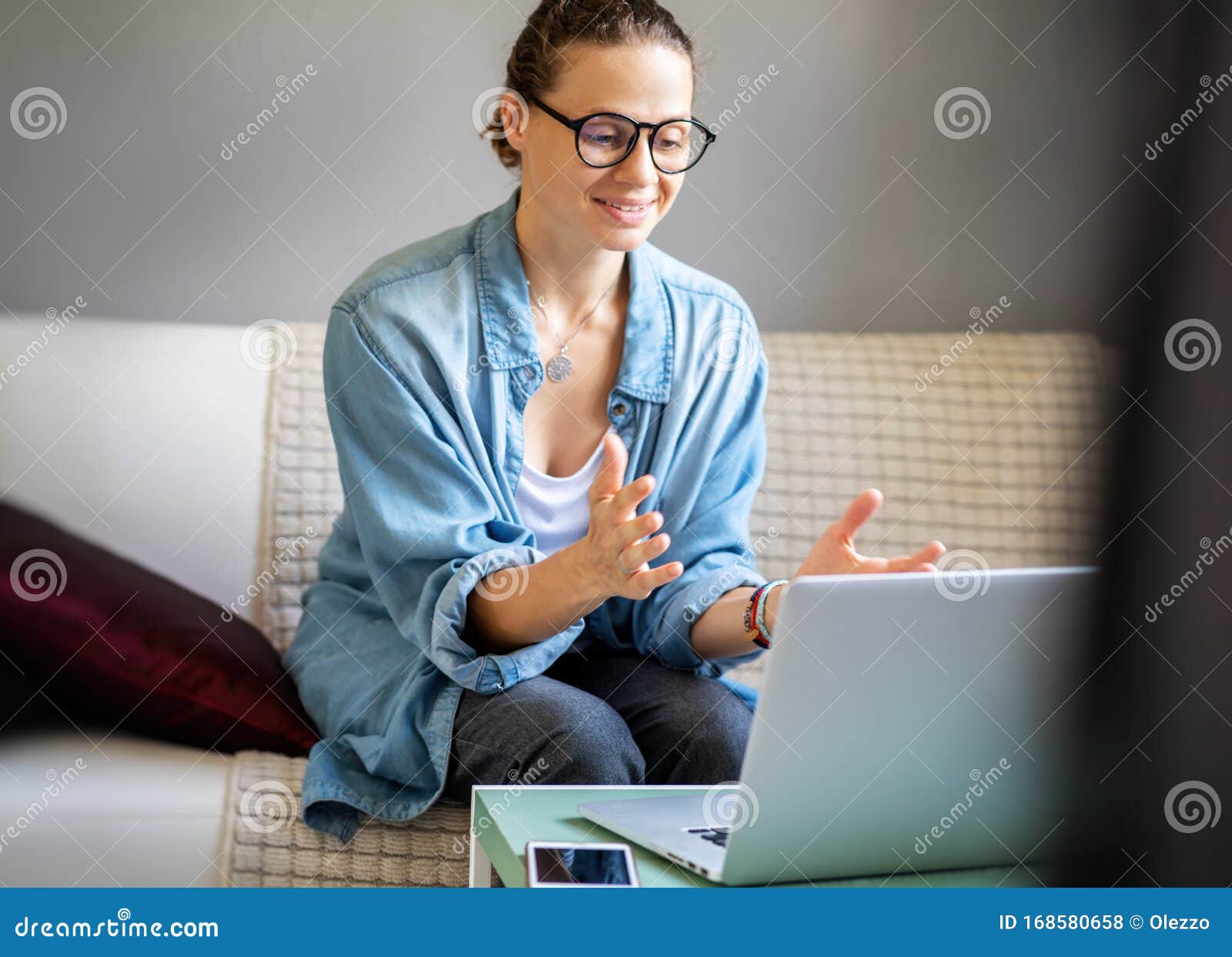 young pretty european woman with glasses psychologist coach holds an online session on the internet, remote work from home, online