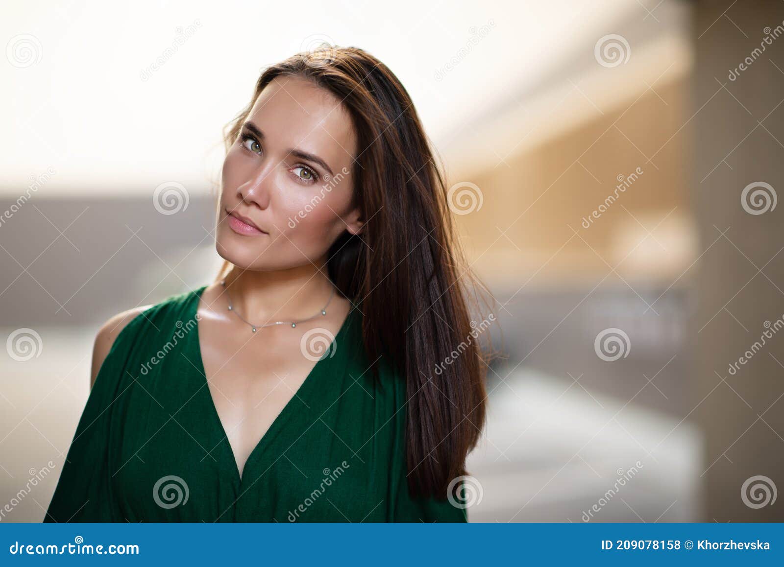 young pretty likable cheerful woman posing summer city outdoor. beautiful self-confident girl dressed in emerald-colored jumpsuit