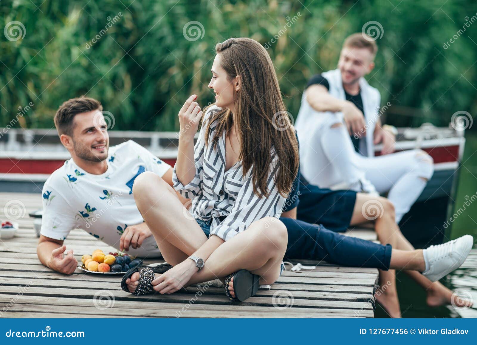 young pretty woman and handsome man flirting while relax on picnic near river