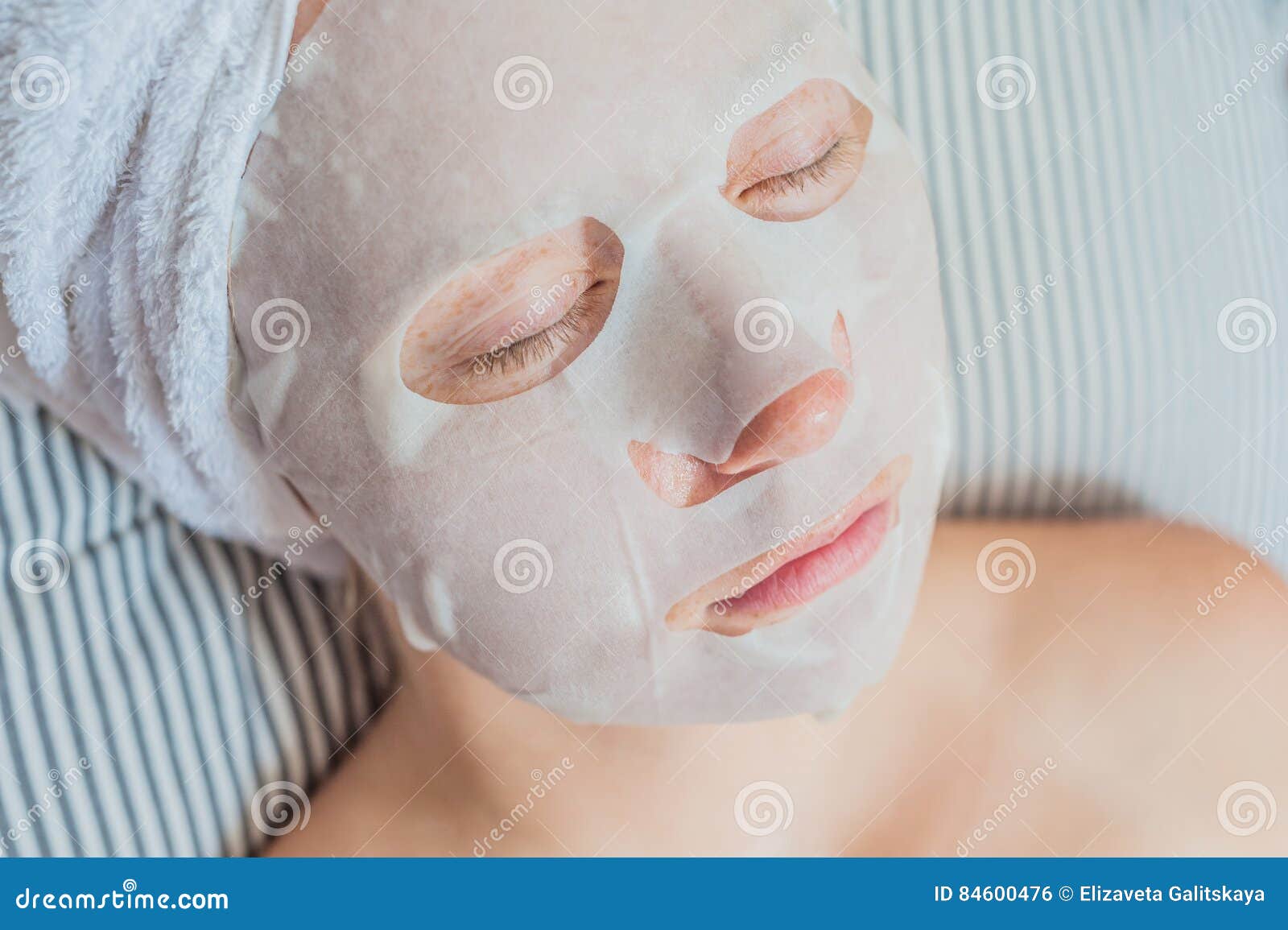 Young Red-haired Woman Relaxing on a Bed. Sheet Mask on Her Face Stock ...