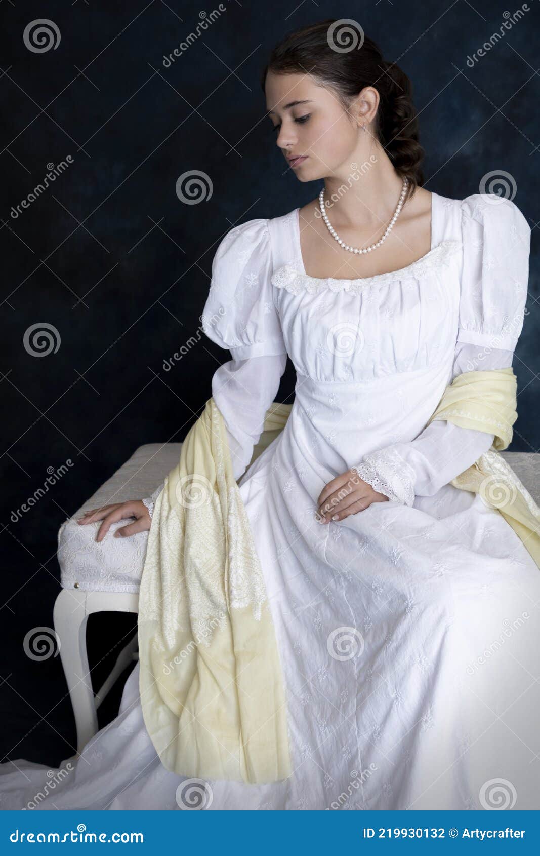 a young regency woman wearing a white muslin dress and a pearl necklace